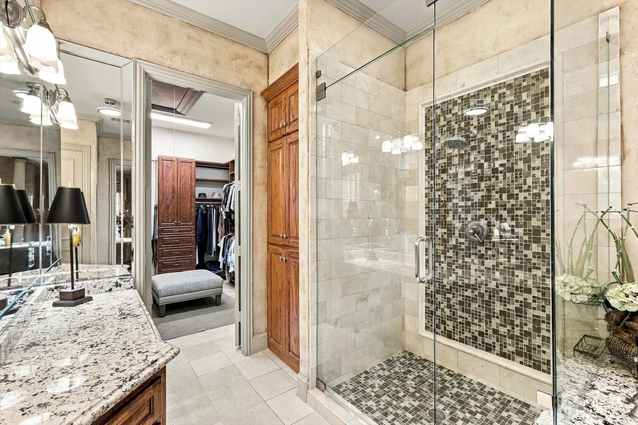 Beautiful tilework and sleek frameless glass elevate the spacious walk-in shower, making it a standout feature of the primary bathroom.