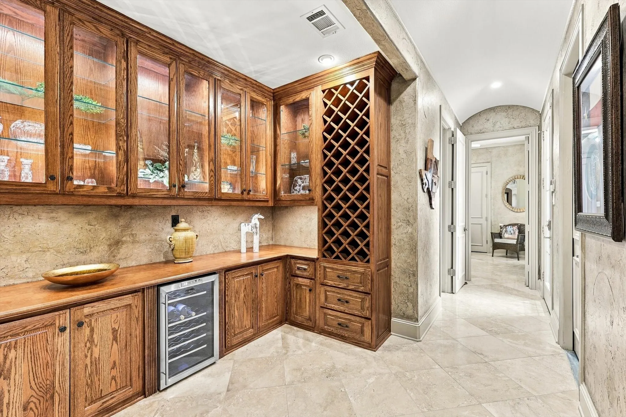 A beautifully appointed bar area makes entertaining easy, with wine storage, a wine fridge, lighted glass-front cabinets and abundant storage for all your entertaining essentials.