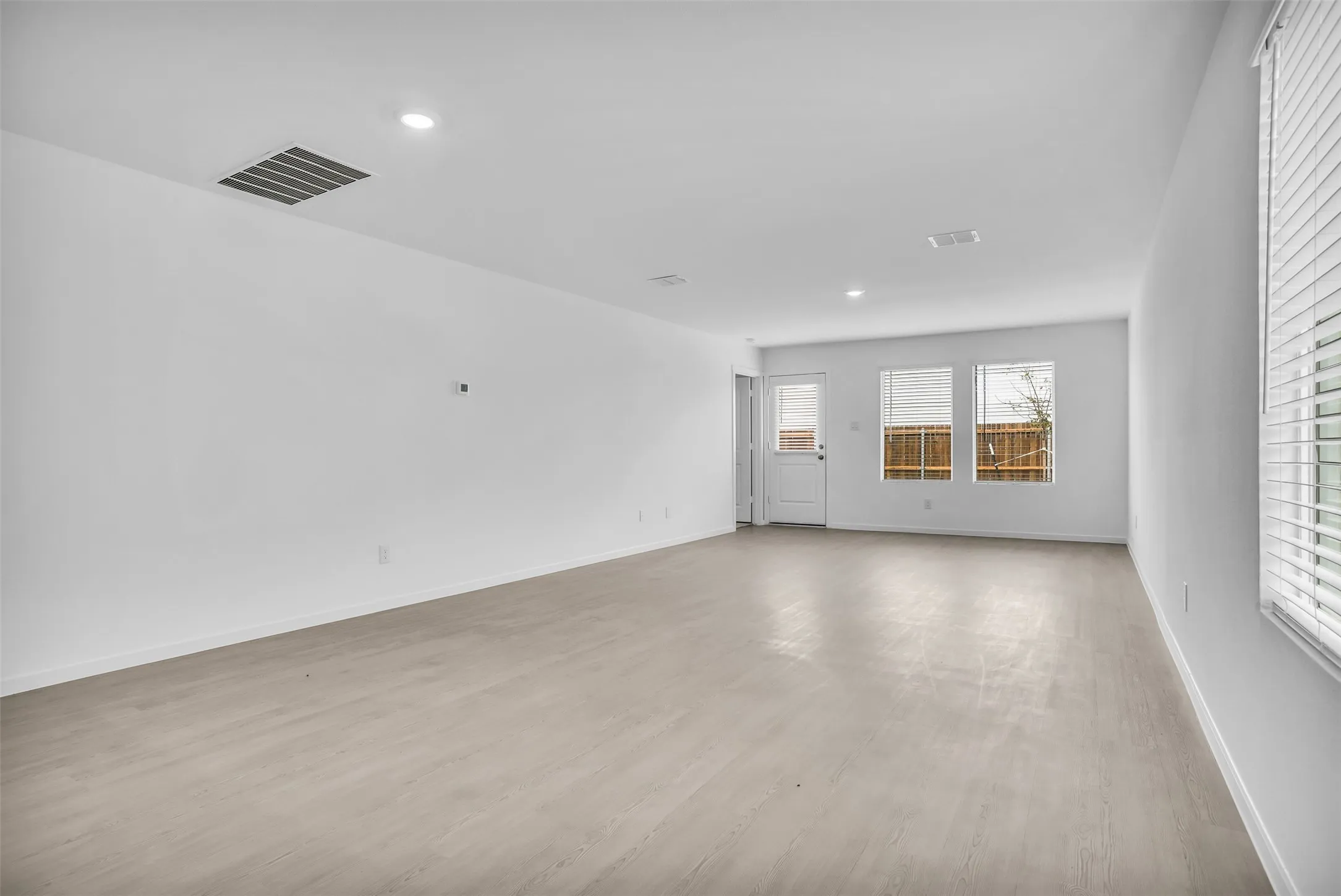 Empty room featuring light wood-style floors and recessed lighting