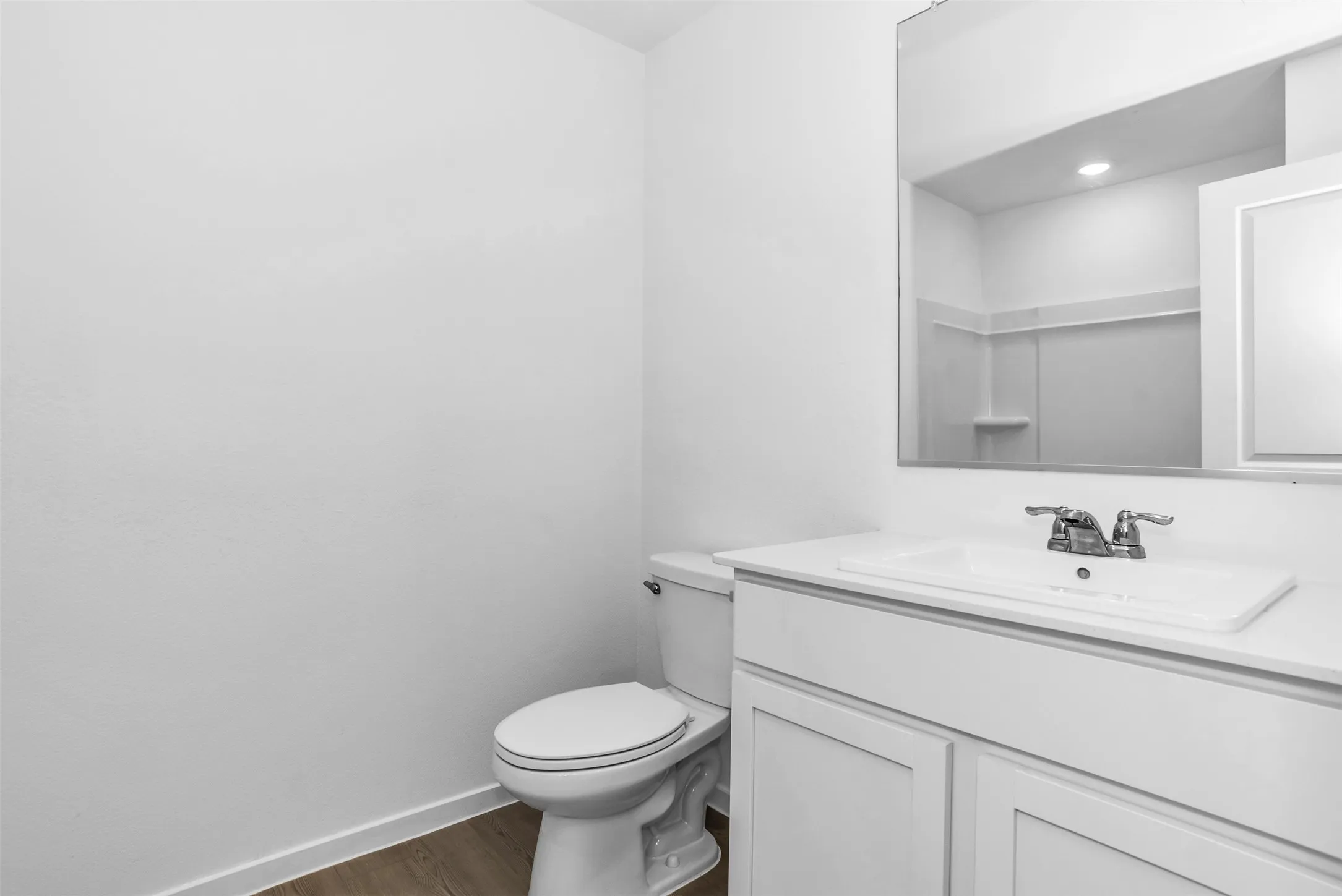 Half bathroom featuring vanity and dark wood finished floors