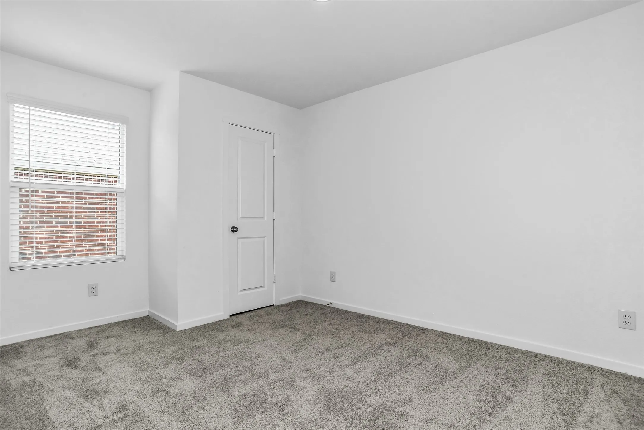 Unfurnished room featuring light carpet and baseboards