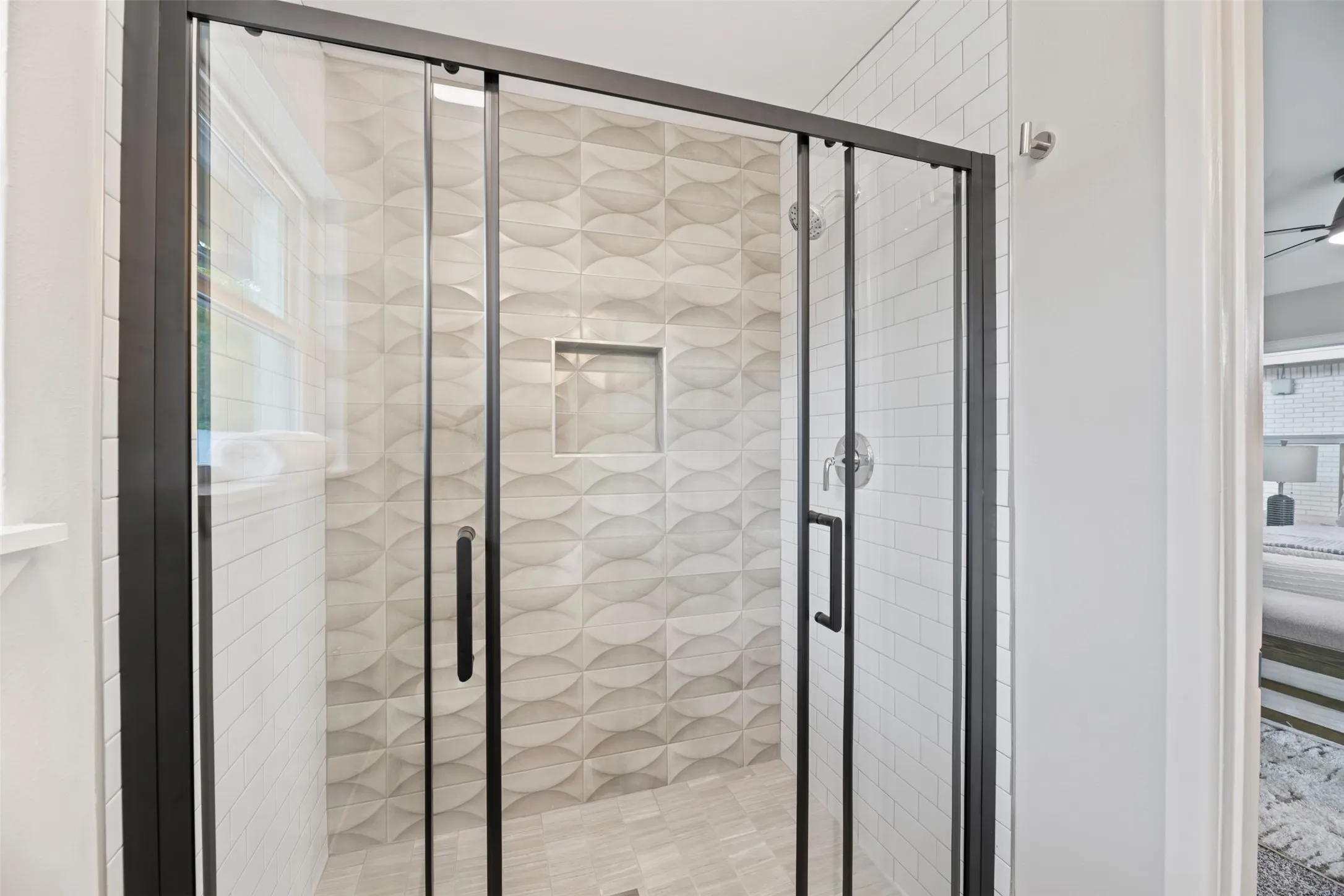 Primary shower has a new door and tile surround