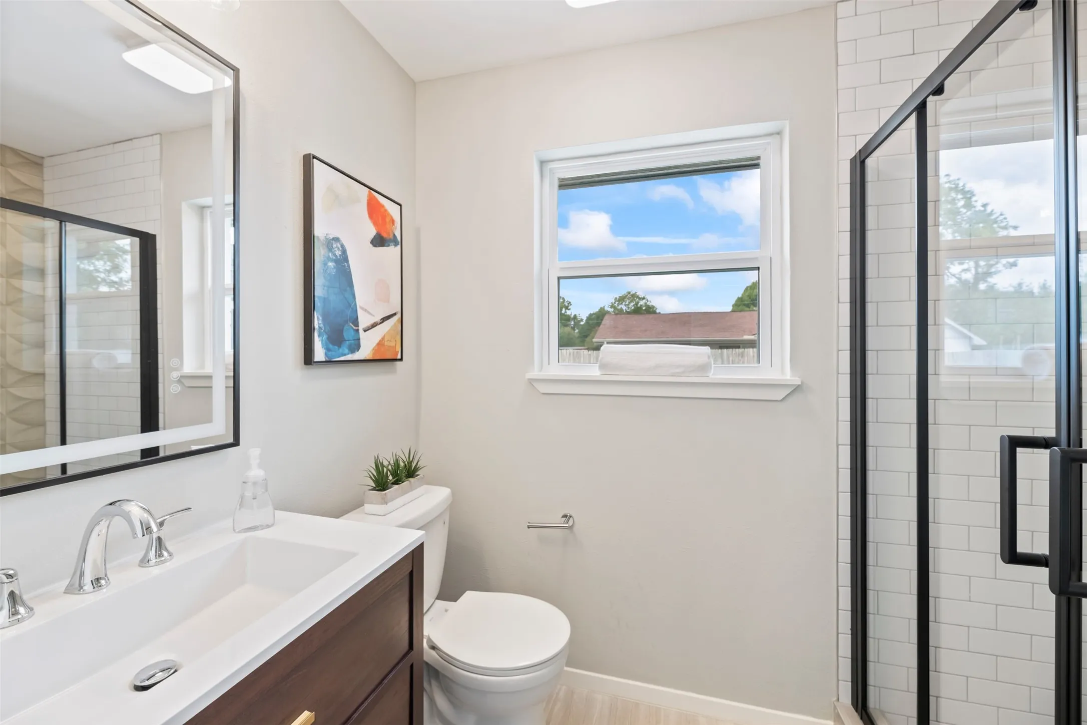Primary bathroom has a new vanity, faucet and LED lit mirror