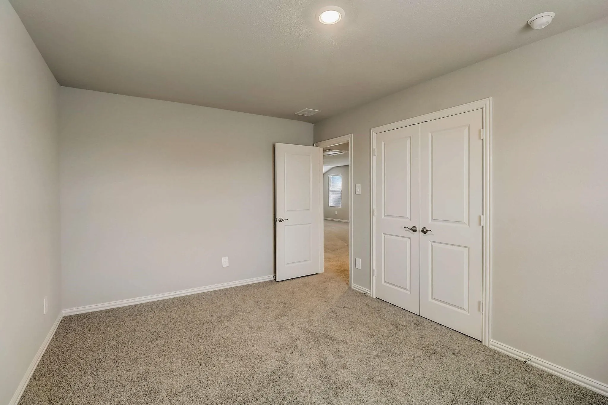 Neutral gray walls, recessed lighting, and soft carpet flooring