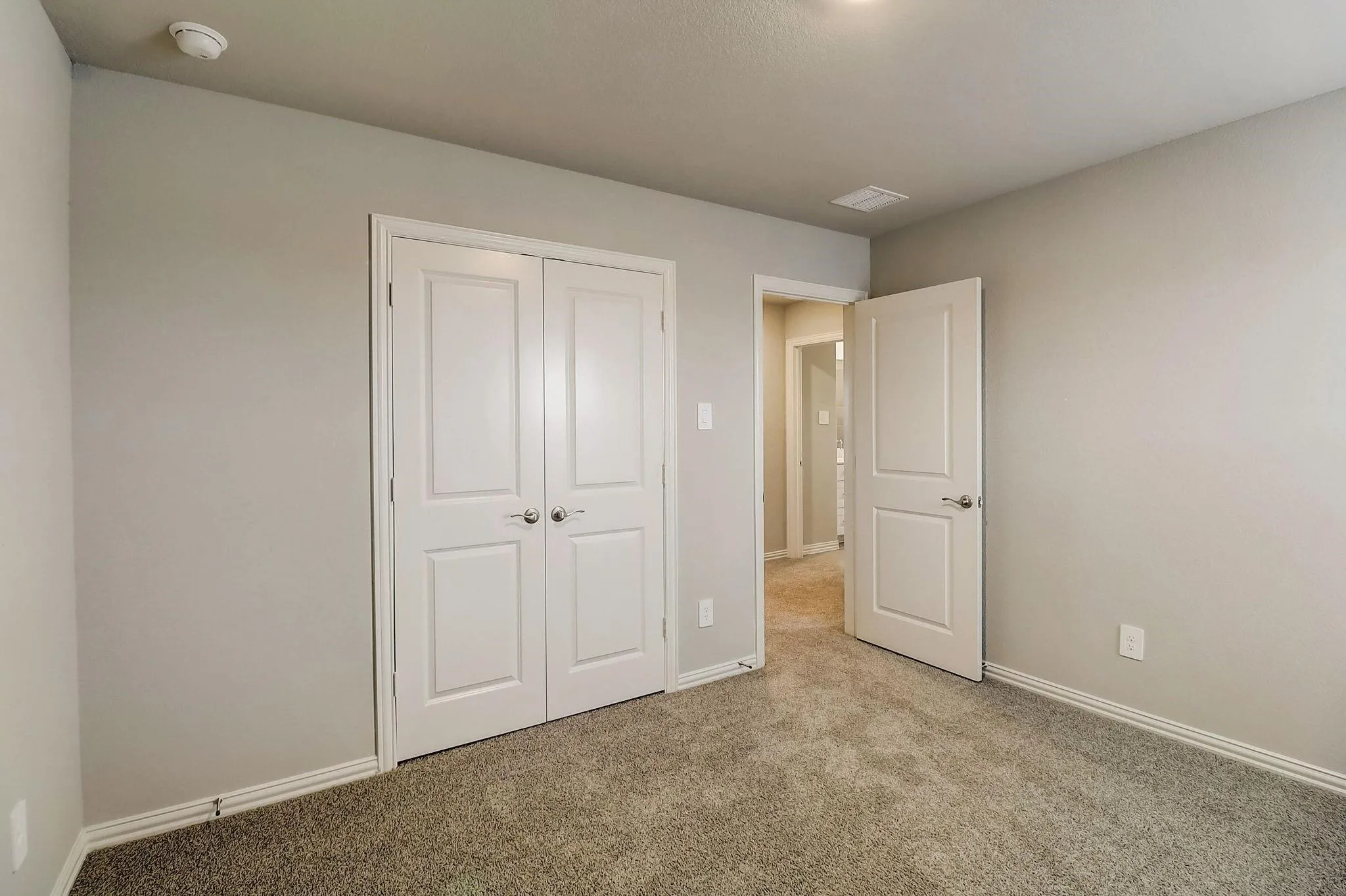 Plush carpet flooring, neutral paint palette, white trim, recessed lighting, and a double-door closet