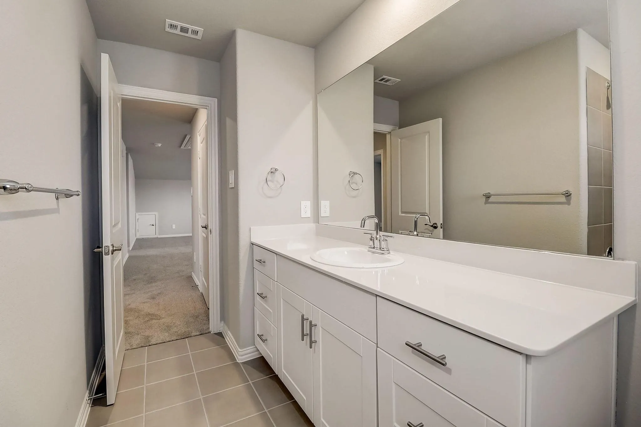 White vanity with cabinet and drawer storage, integrated sink, and polished chrome faucet