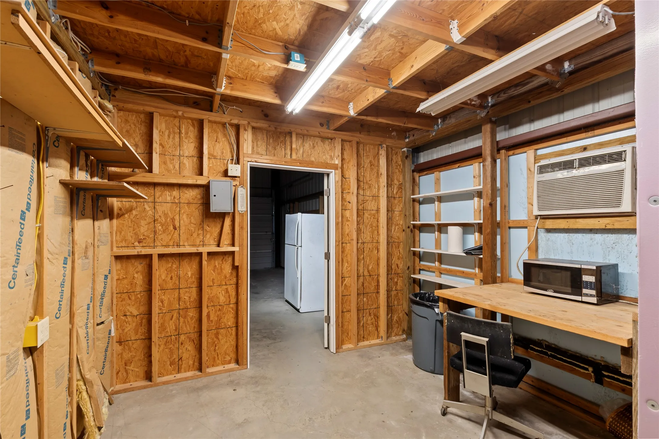 Room in metal building with window unit and full bath makes a great office or even sleeping area.