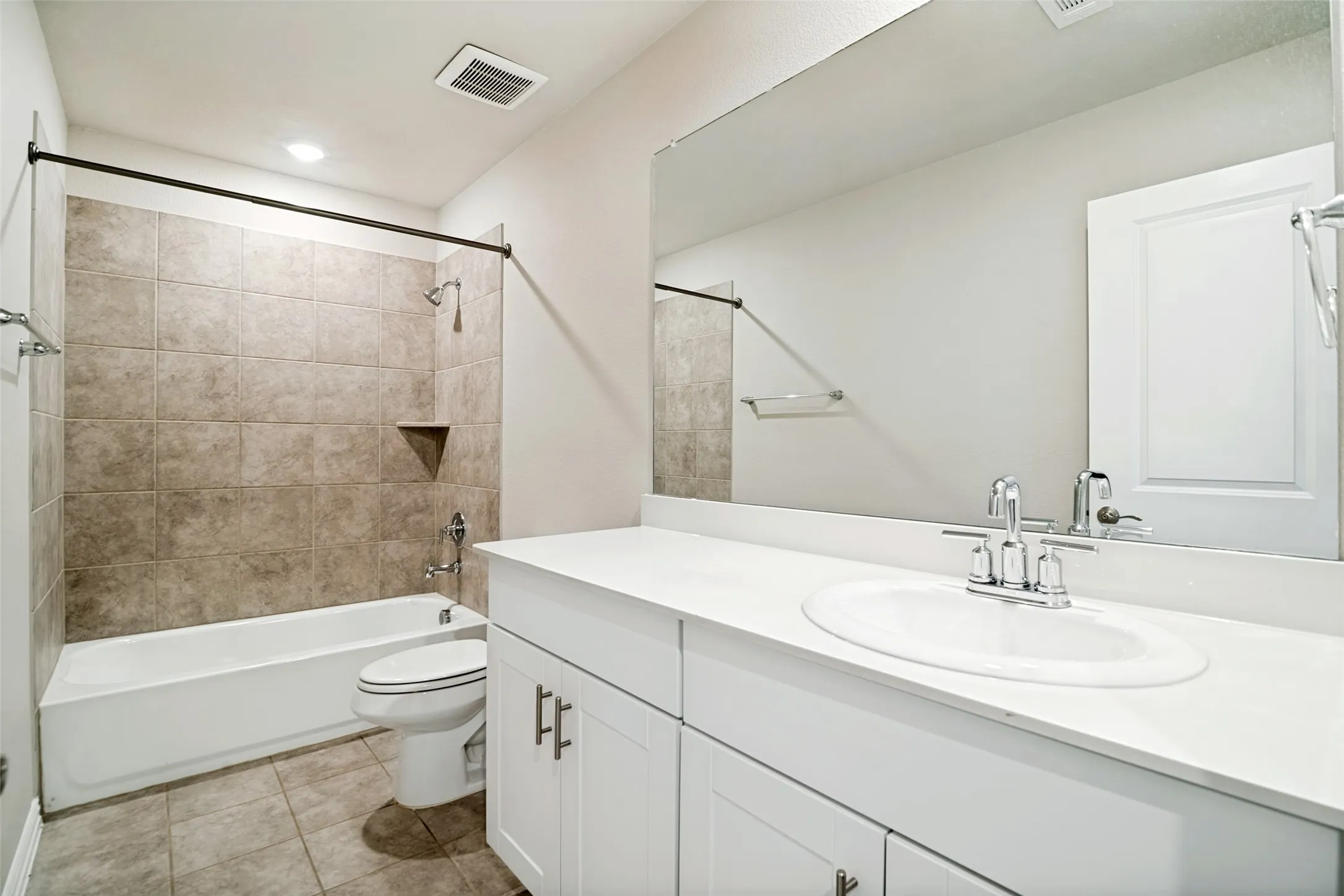 White vanity with brushed nickel hardware, integrated sink, and a large wall-mounted mirror