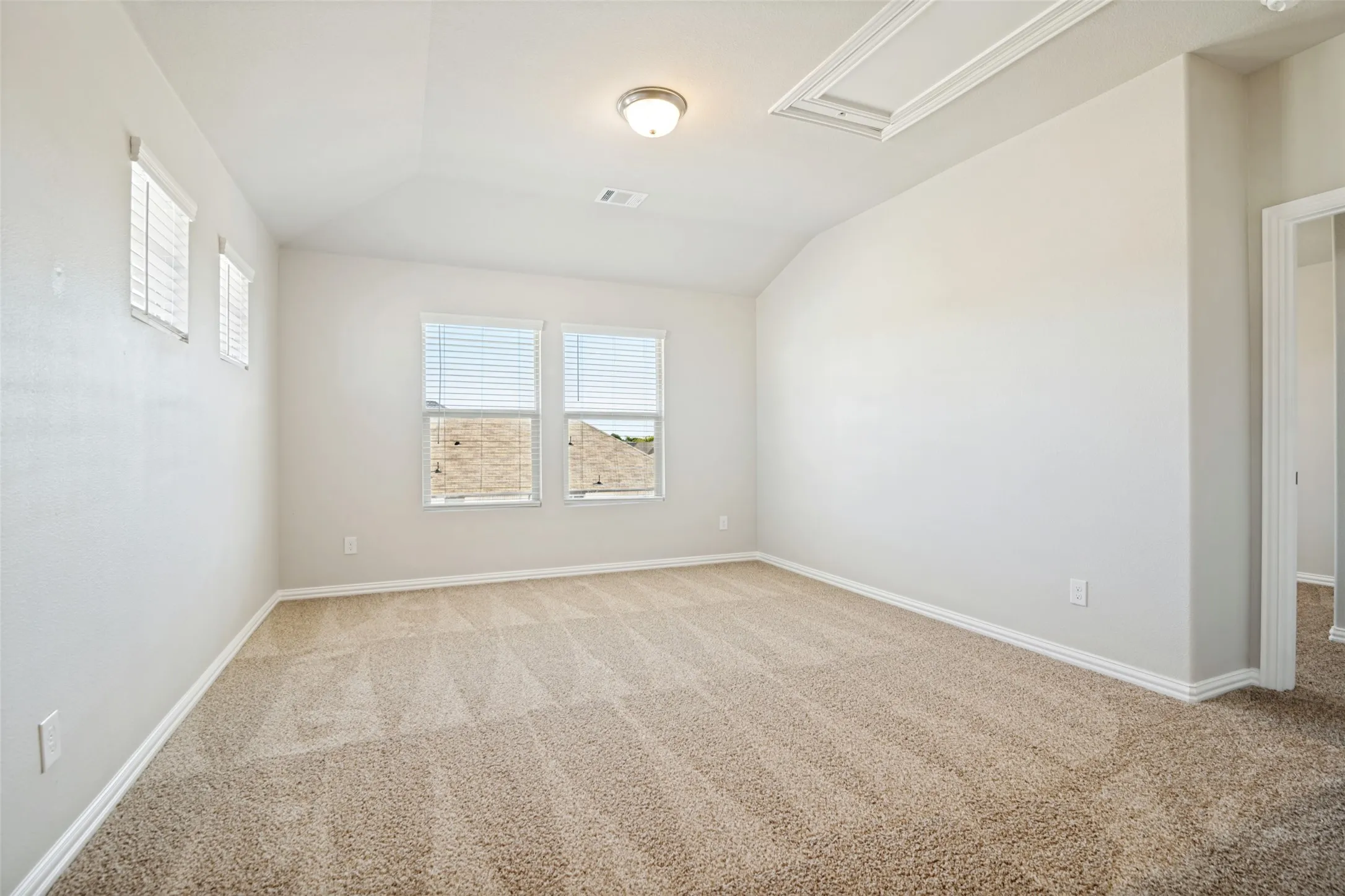 Neutral-toned carpeting with a textured pattern, vaulted ceiling, and recessed lighting