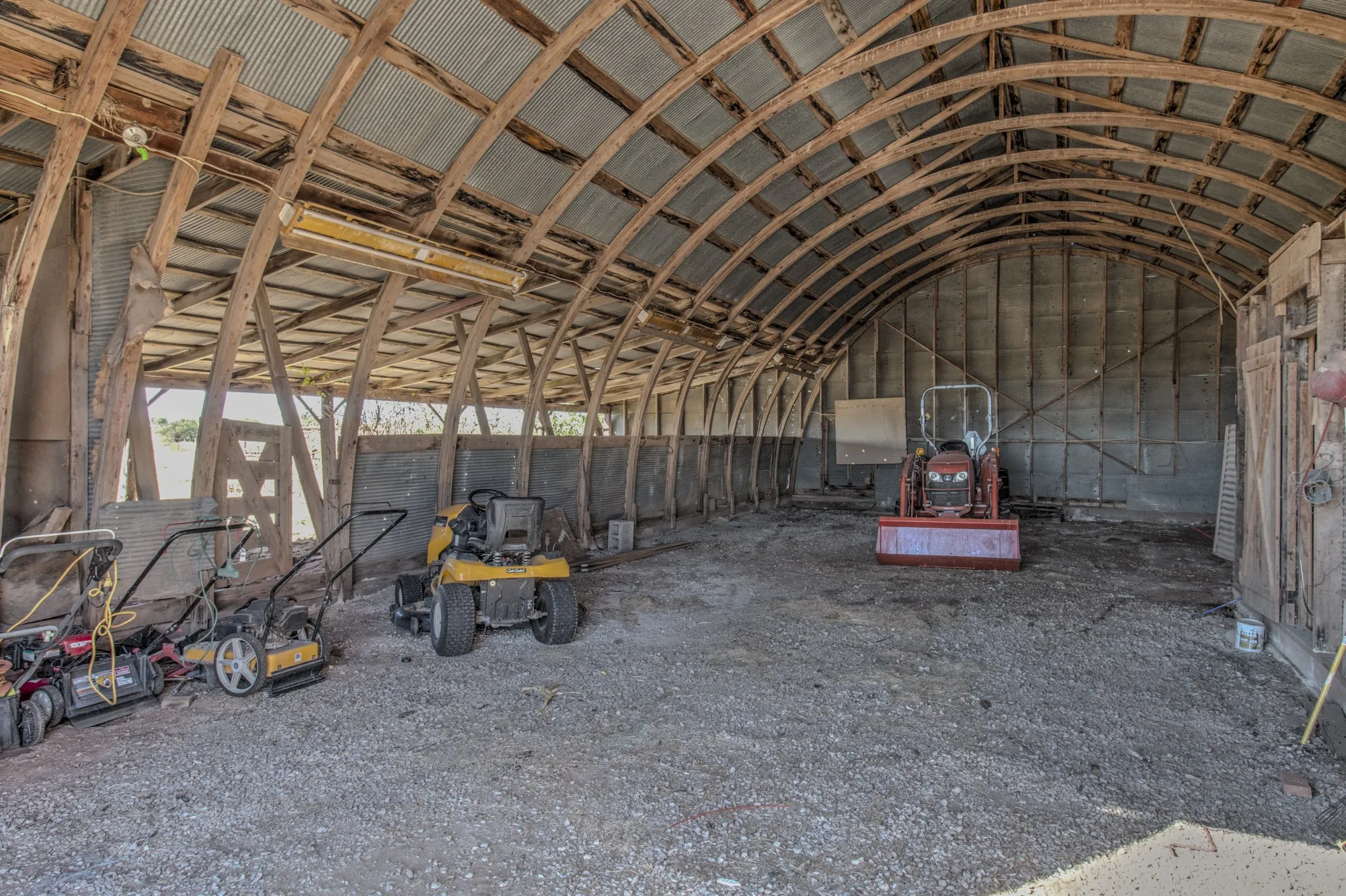 Original barn offering ample space for equipment, tractors, tools, and storage, showcasing the authentic character.