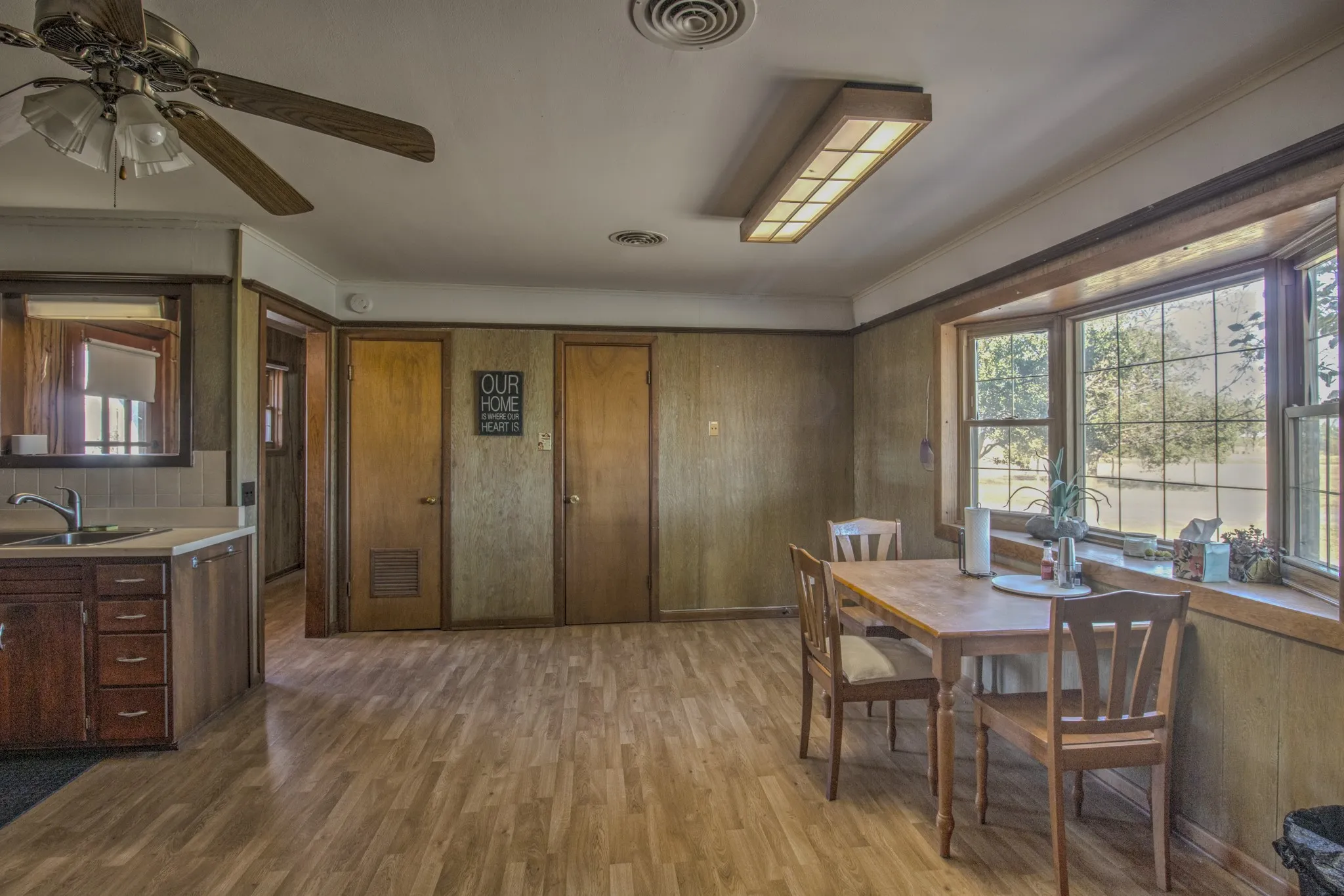 Bright and spacious eat-in kitchen and dining area featuring an abundance of natural light, generous windows overlooking the property, and a functional open layout.