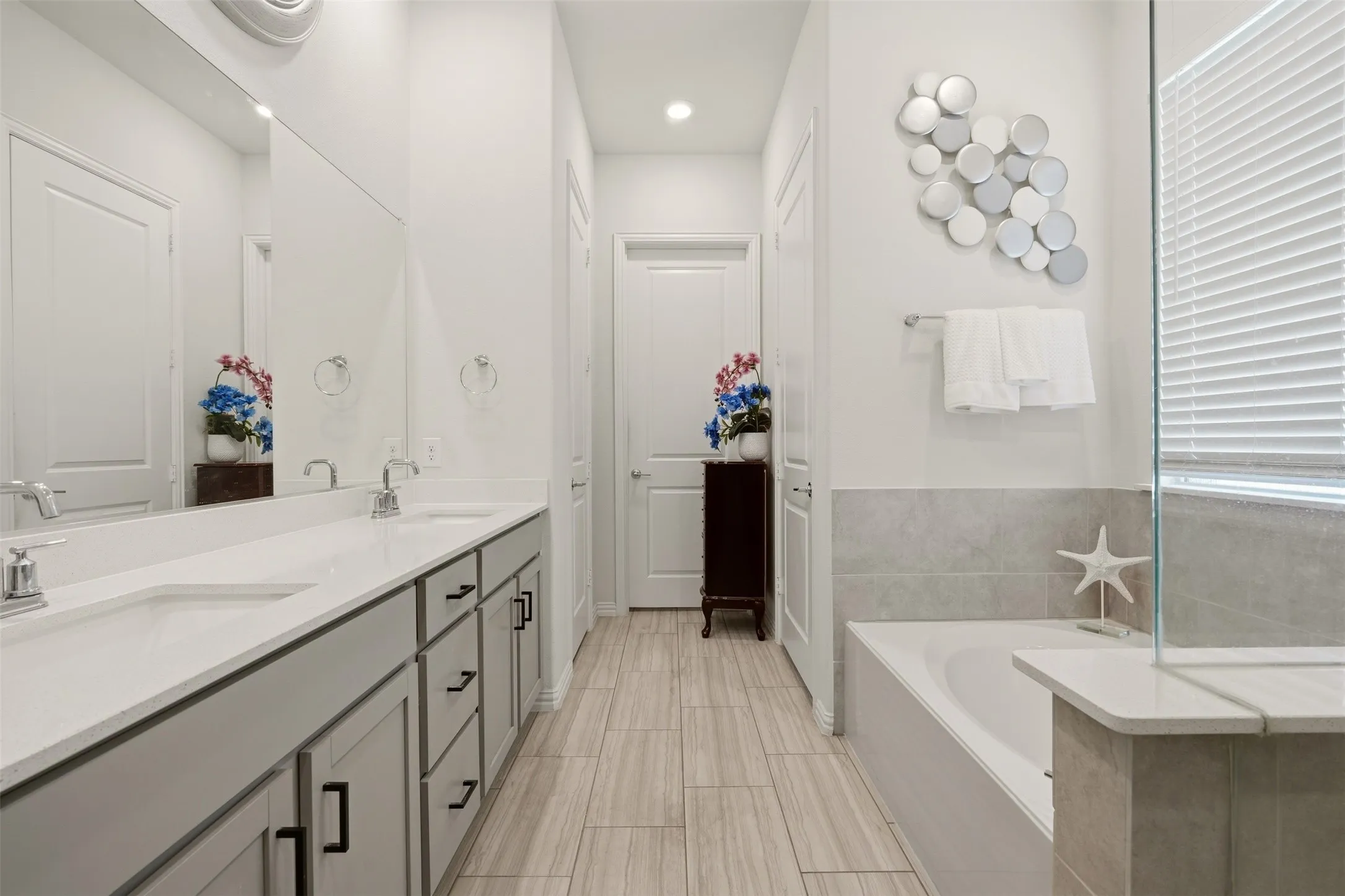 Dual vanity with undermount sinks, light-toned cabinetry, and extensive countertop space
