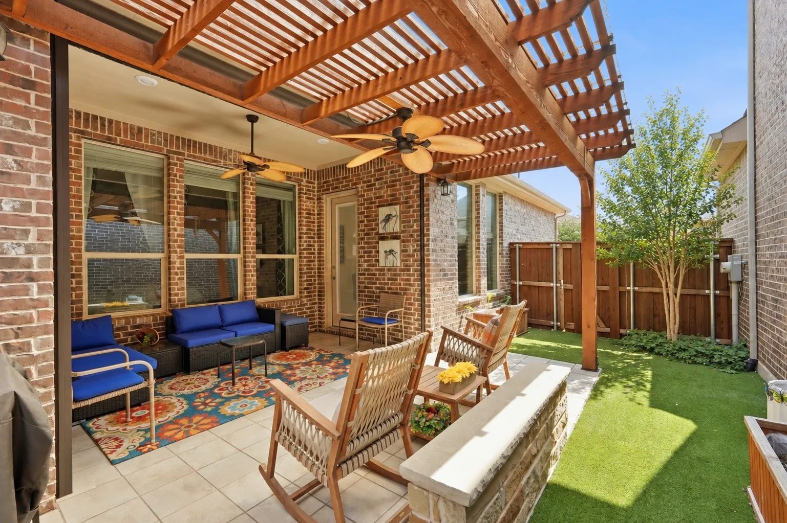 Outdoor patio with tile flooring, wood pergola, and ceiling fans