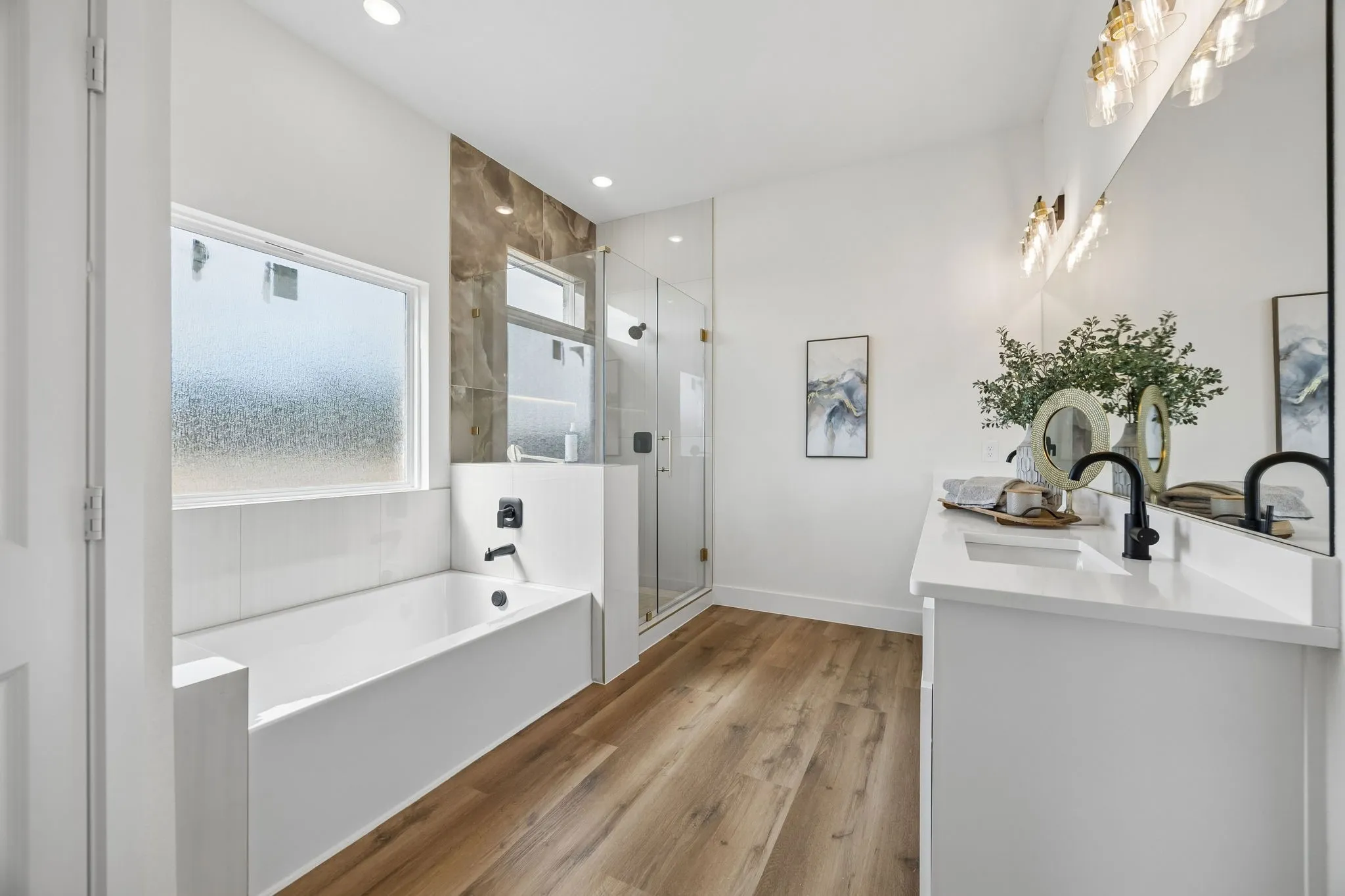 Ensuite primary bathroom with a soaking tub, separate glass-enclosed shower and oversized vanity