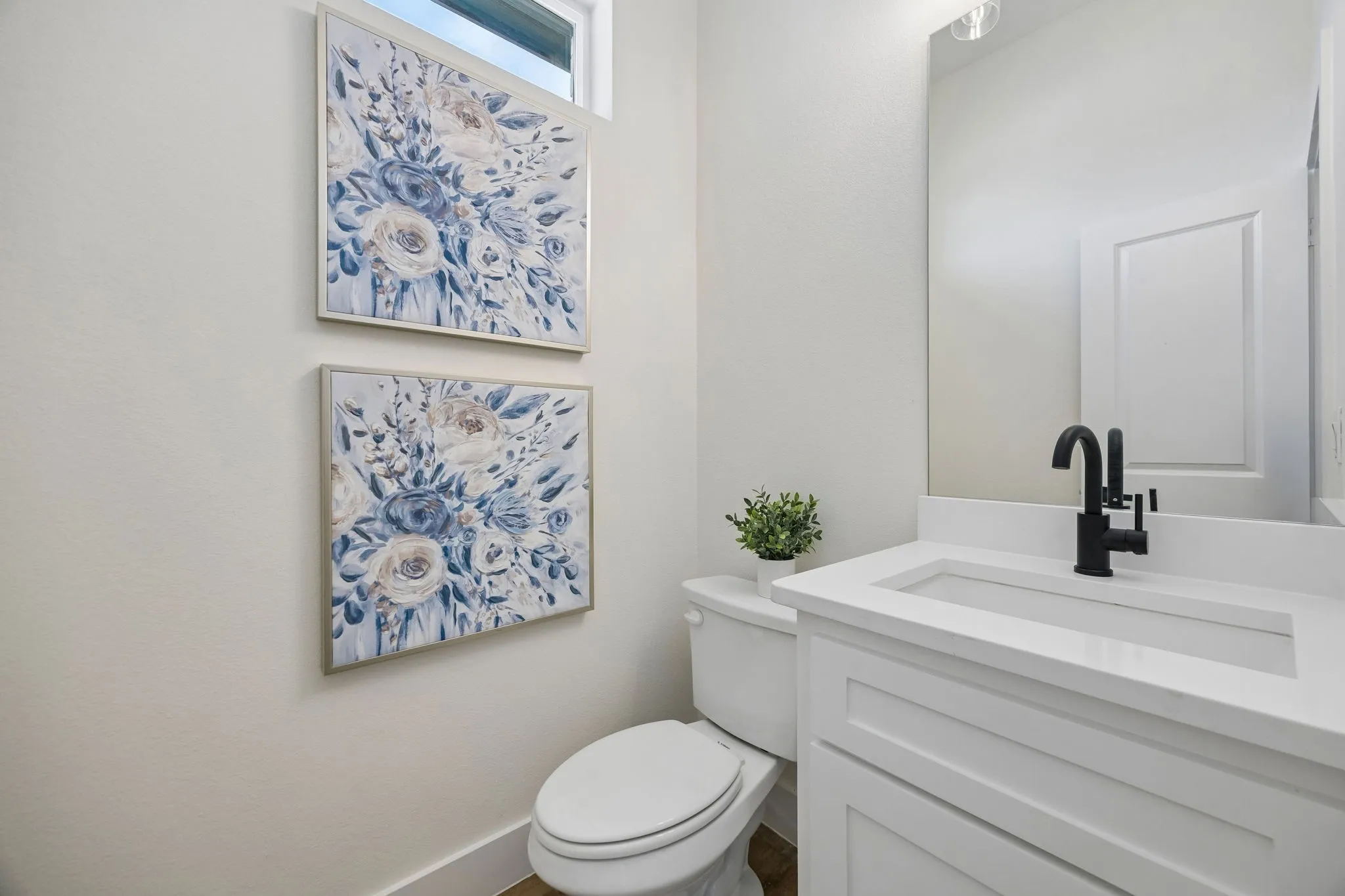 White vanity with integrated rectangular sink, matte black single-handle faucet, and white countertop