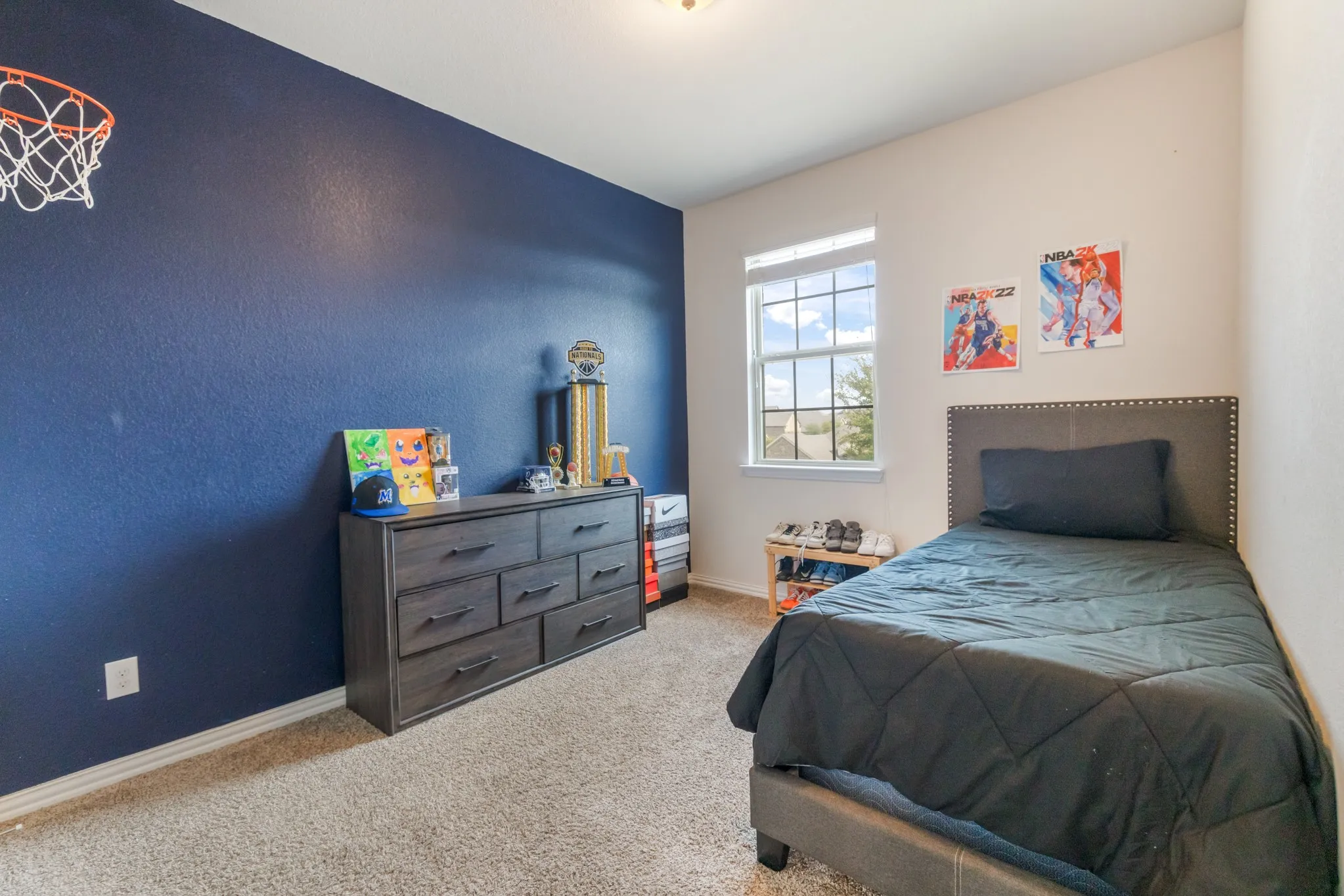 Carpeted bedroom with a single window and a contrasting accent wall