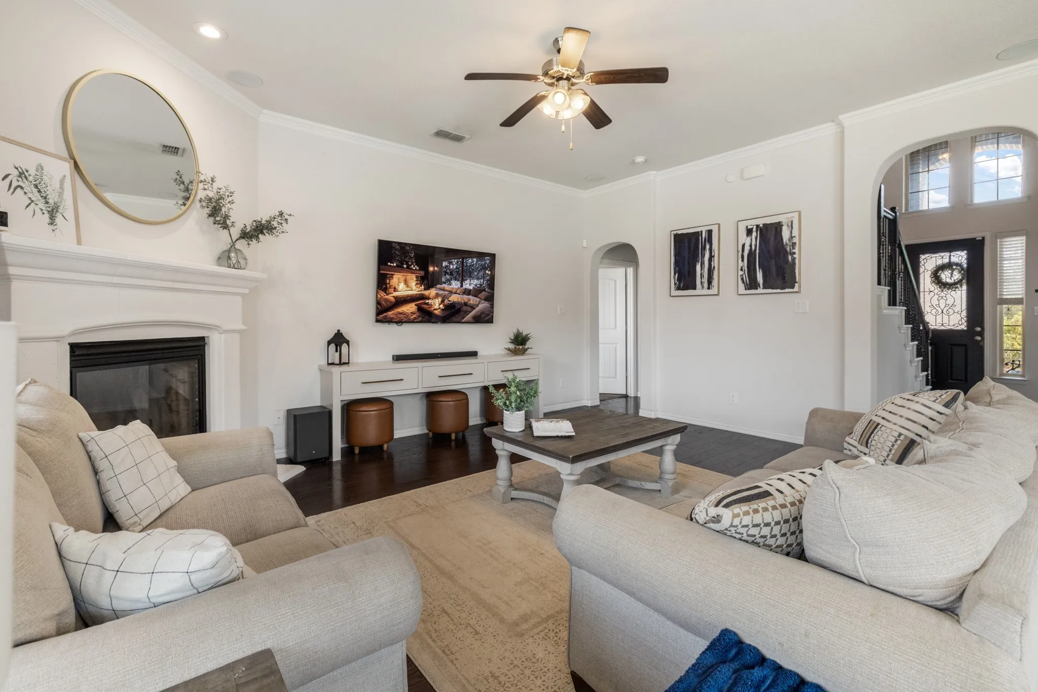 Living area featuring a fireplace with a white mantel, dark wood-finish flooring, and white walls