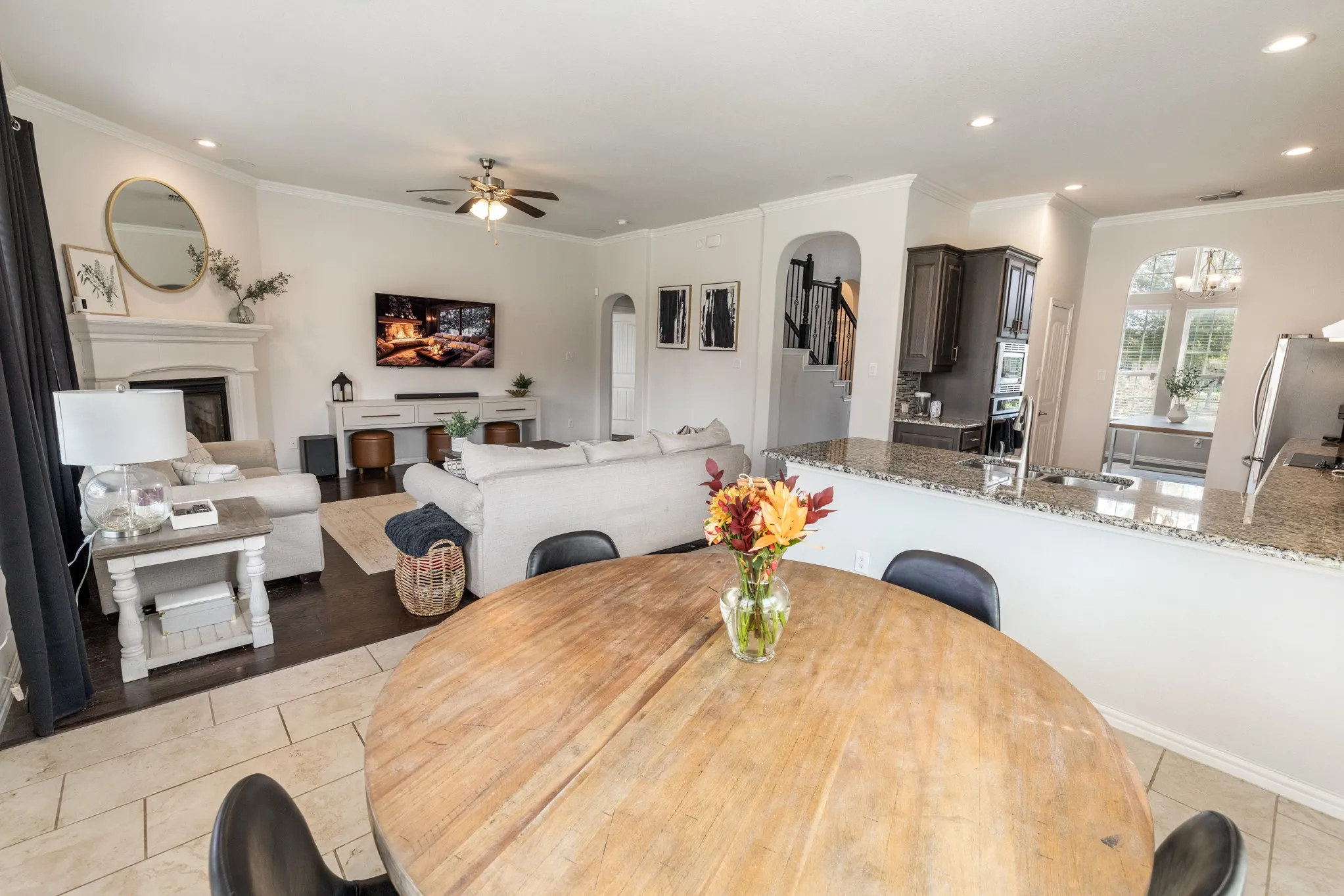 Open-concept design featuring wood-finish flooring, a fireplace with a mantel, and recessed lighting