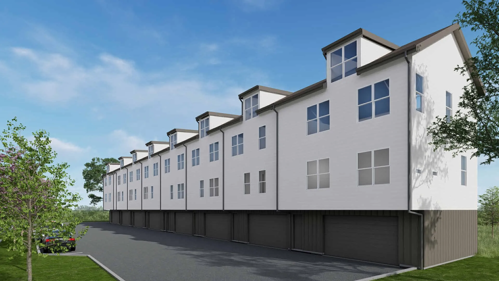 Modern multi-story townhomes featuring dormer windows, attached garages, and a paved parking area