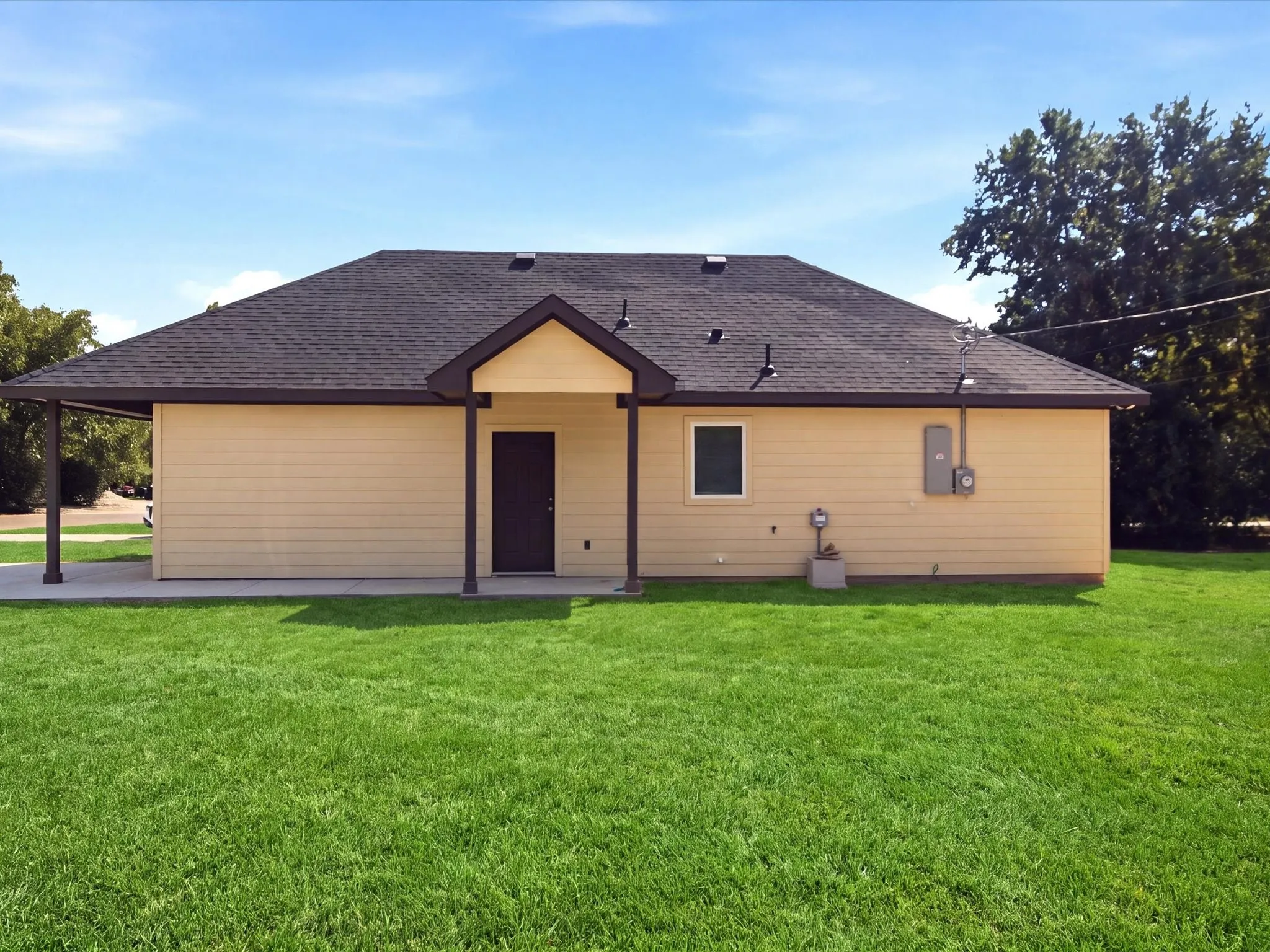 Siding exterior with a dark shingle roof, covered patio, and a covered entryway