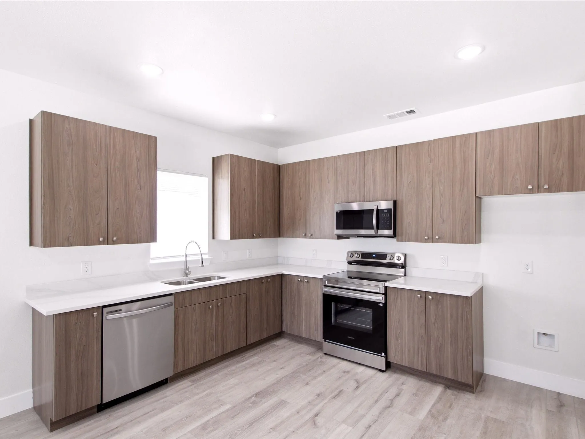 Kitchen featuring wood-finish cabinetry, white countertops, a stainless steel dishwasher, a stainless steel range, and a stainless steel microwave