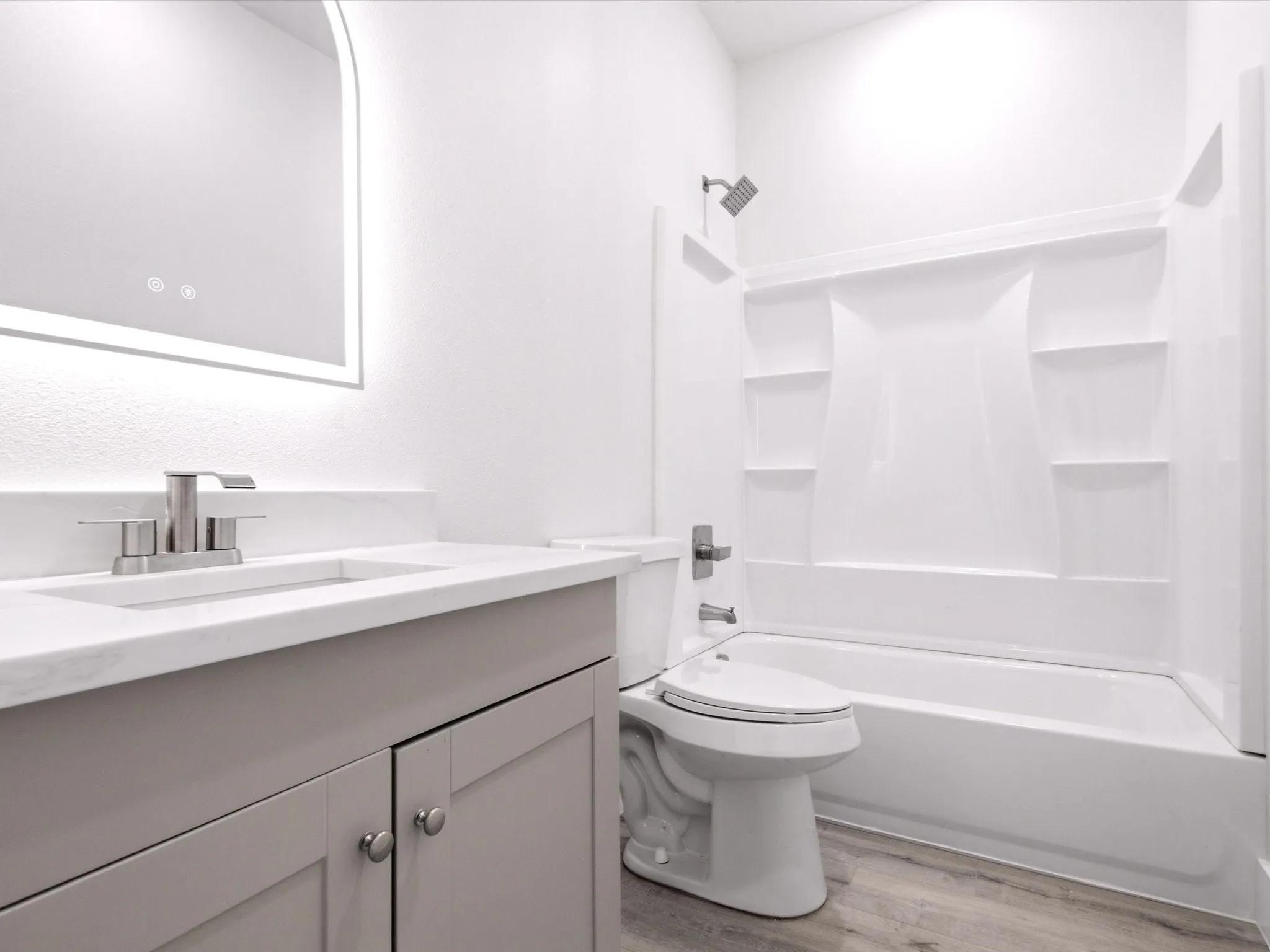 Bathroom featuring a light gray vanity with a white countertop, undermount sink, and brushed nickel faucet
