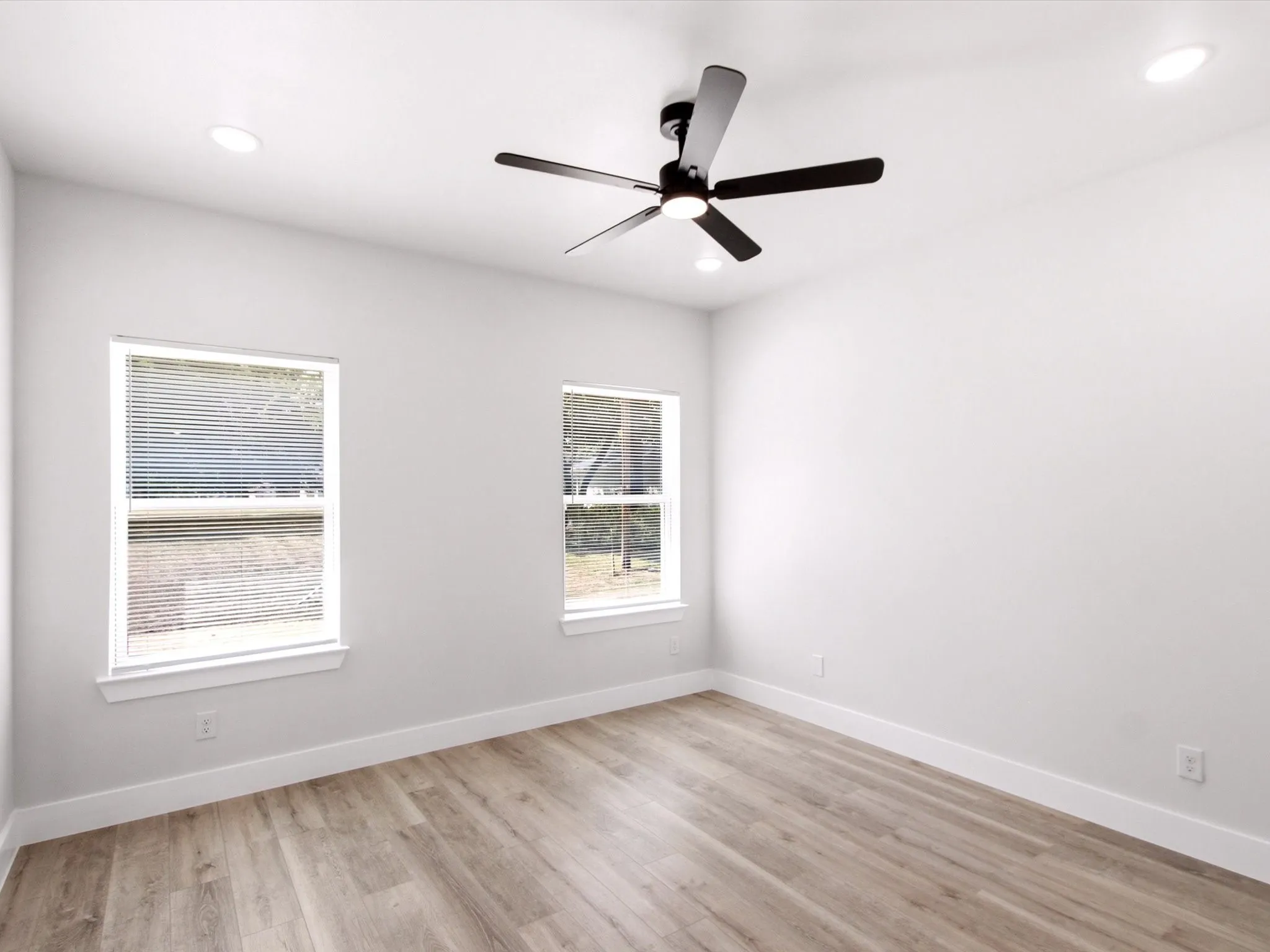 Wood-finish flooring, recessed lighting, and a ceiling fan with integrated lighting