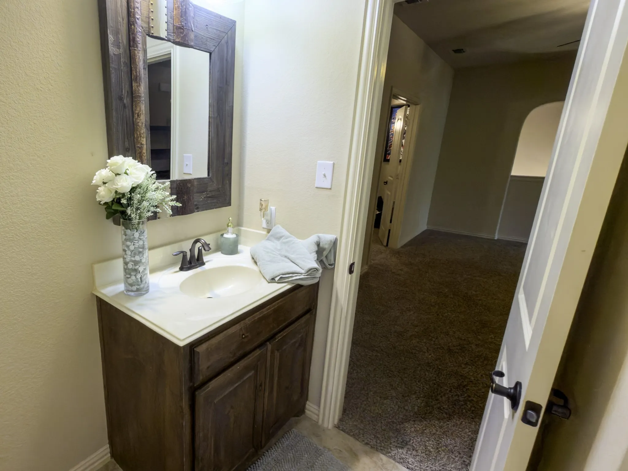 Vanity with a wood-finish cabinet, integrated sink, and bronze-finish faucet