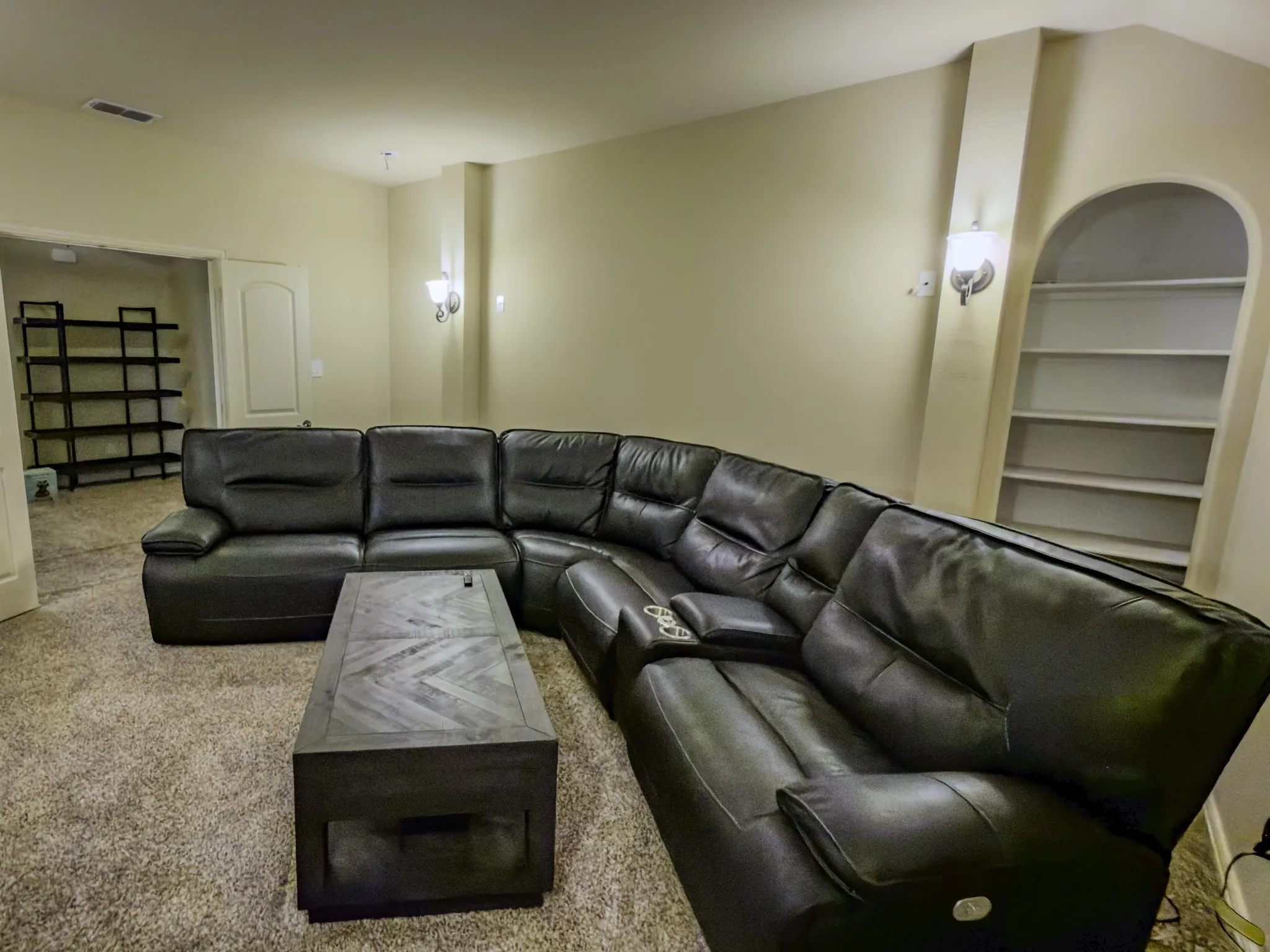 Integrated arched built-in shelving, wall sconce lighting, and ceiling-mounted light fixtures