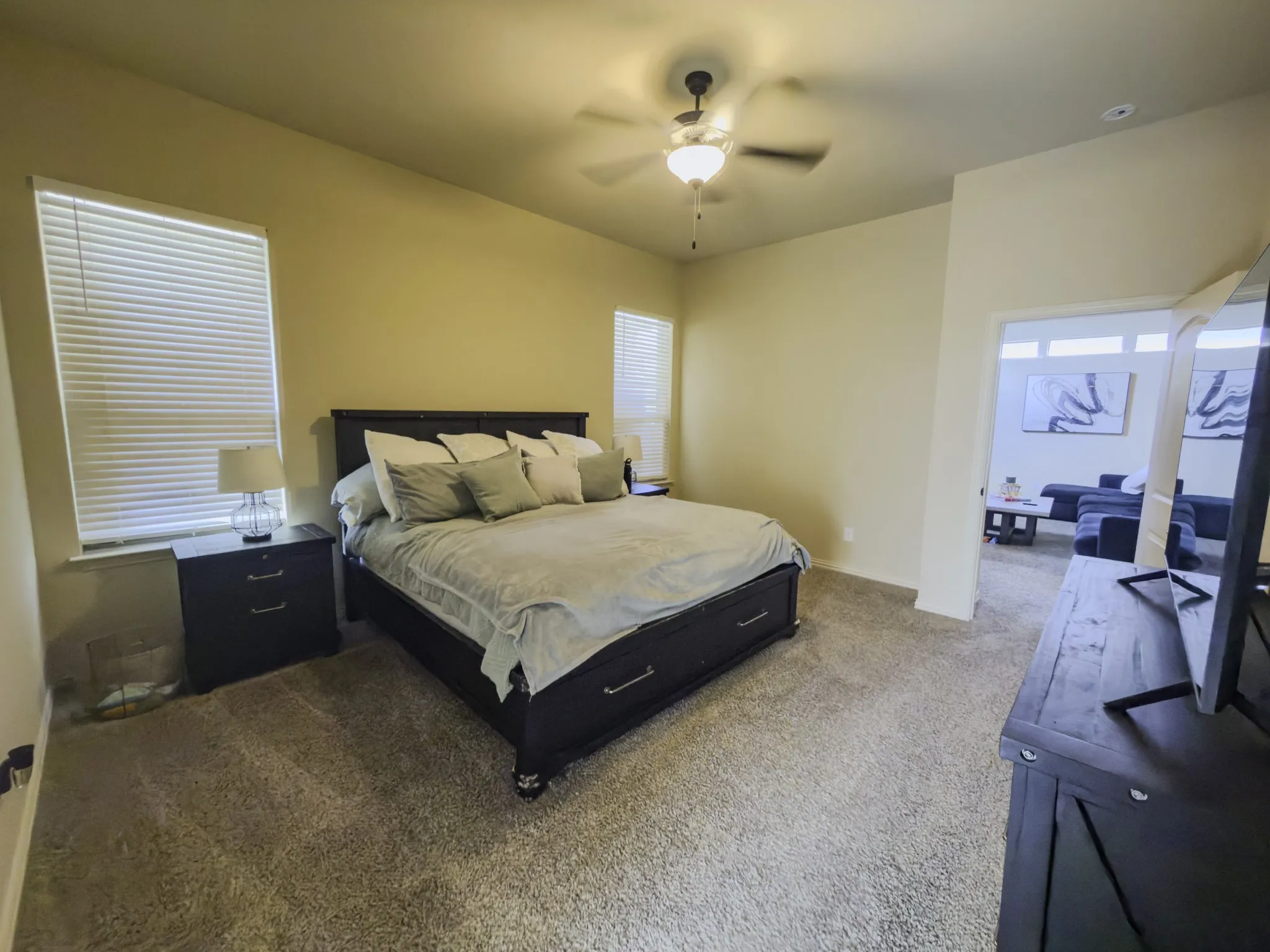 Plush carpeting, vaulted ceiling, and an overhead ceiling fan with lighting