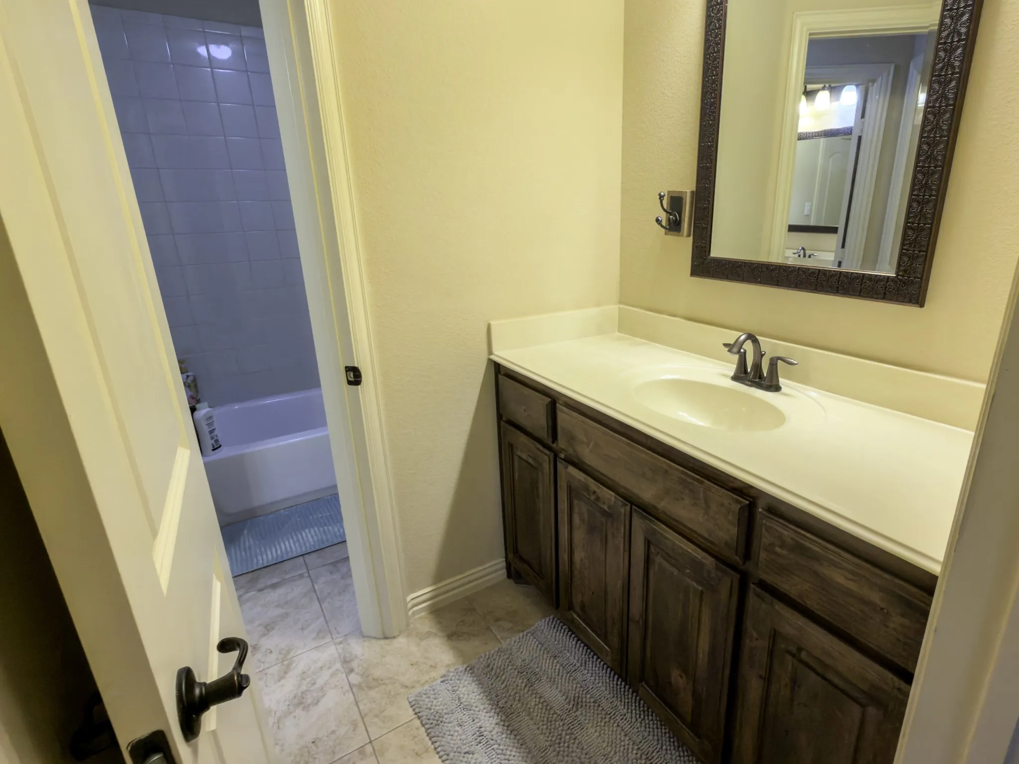 White vanity countertop with an integrated sink and a dark-toned cabinet