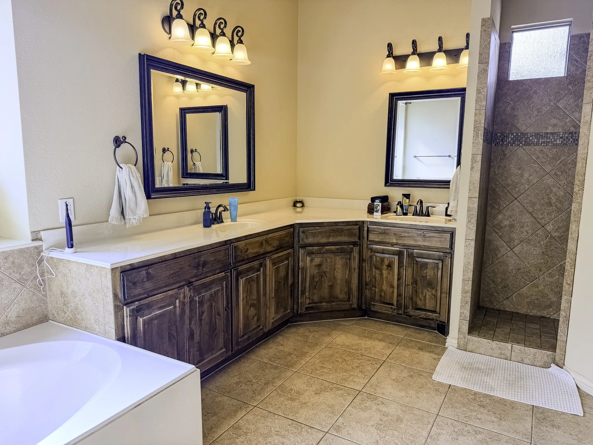 Dual vanities with wood-finish cabinetry and light-toned countertops