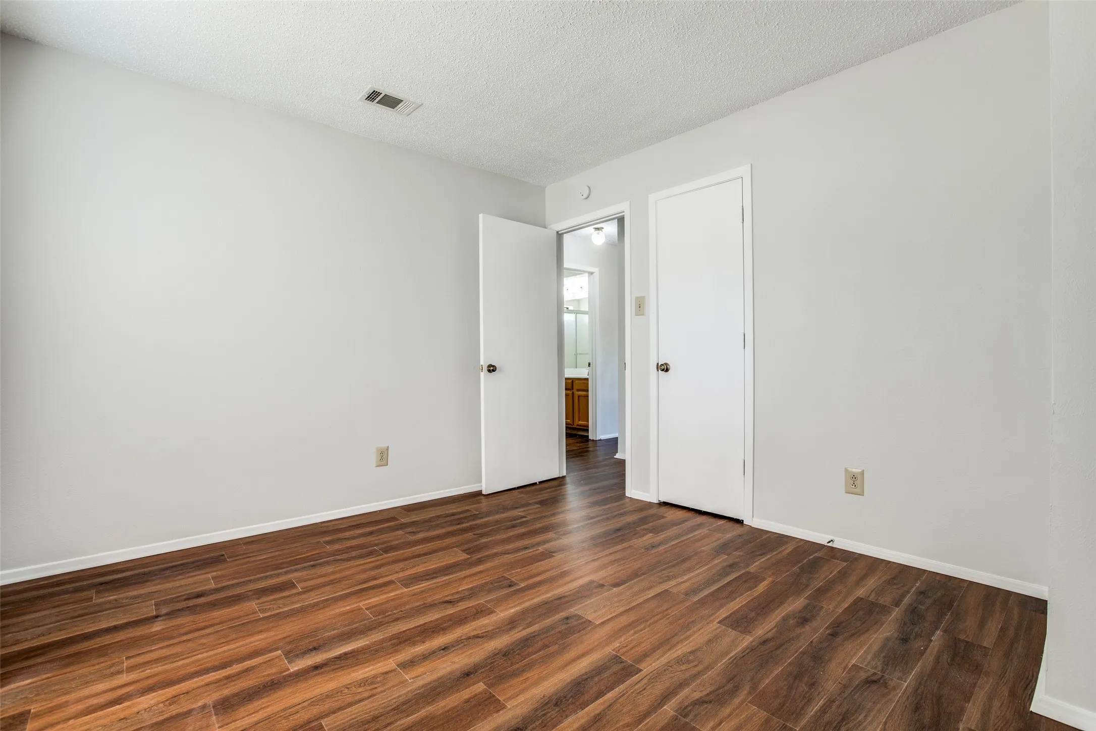 Neutral wall paint, wood-finish flooring, and white trim