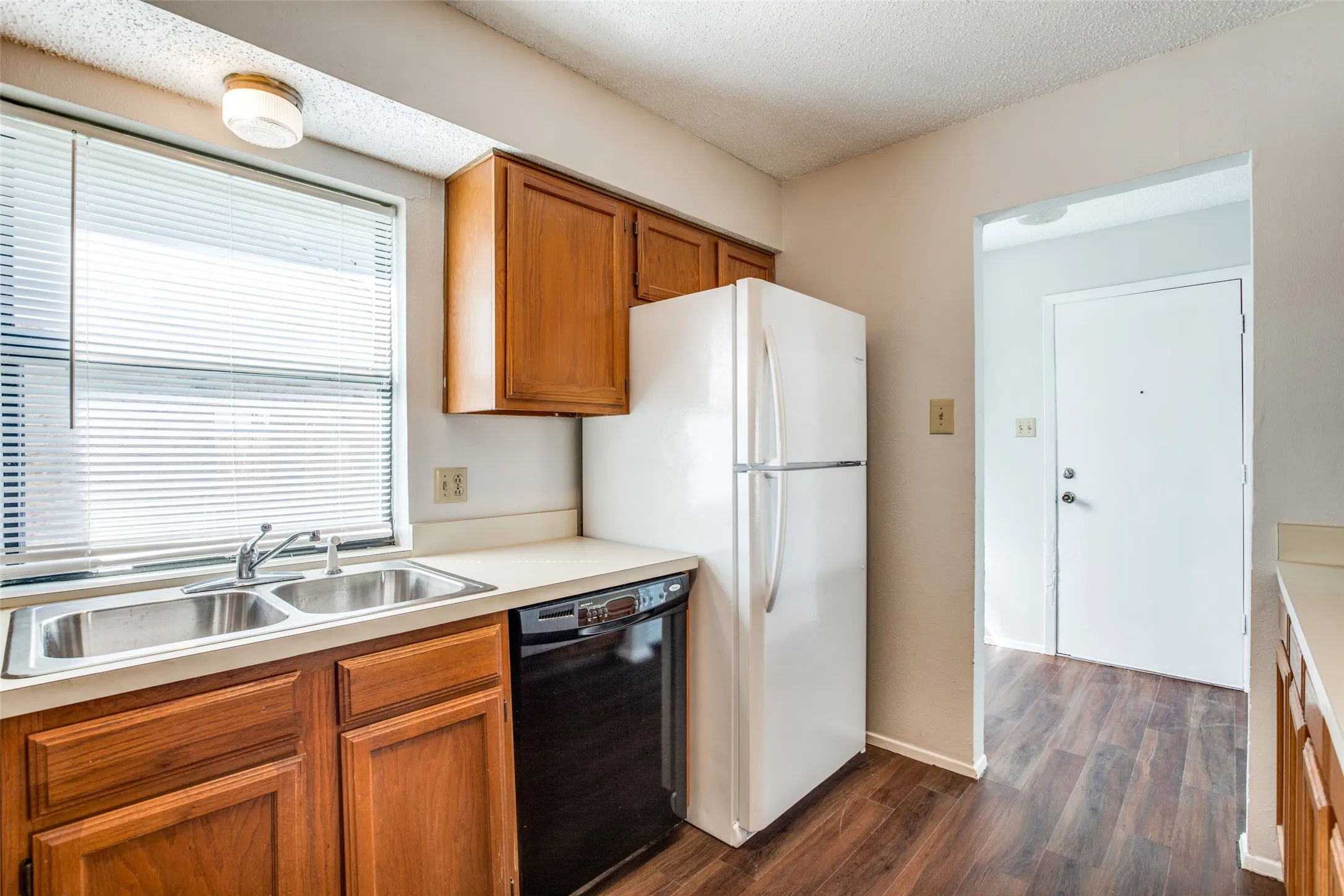 Kitchen featuring wood-finish flooring, a double basin stainless steel sink, and wood cabinetry