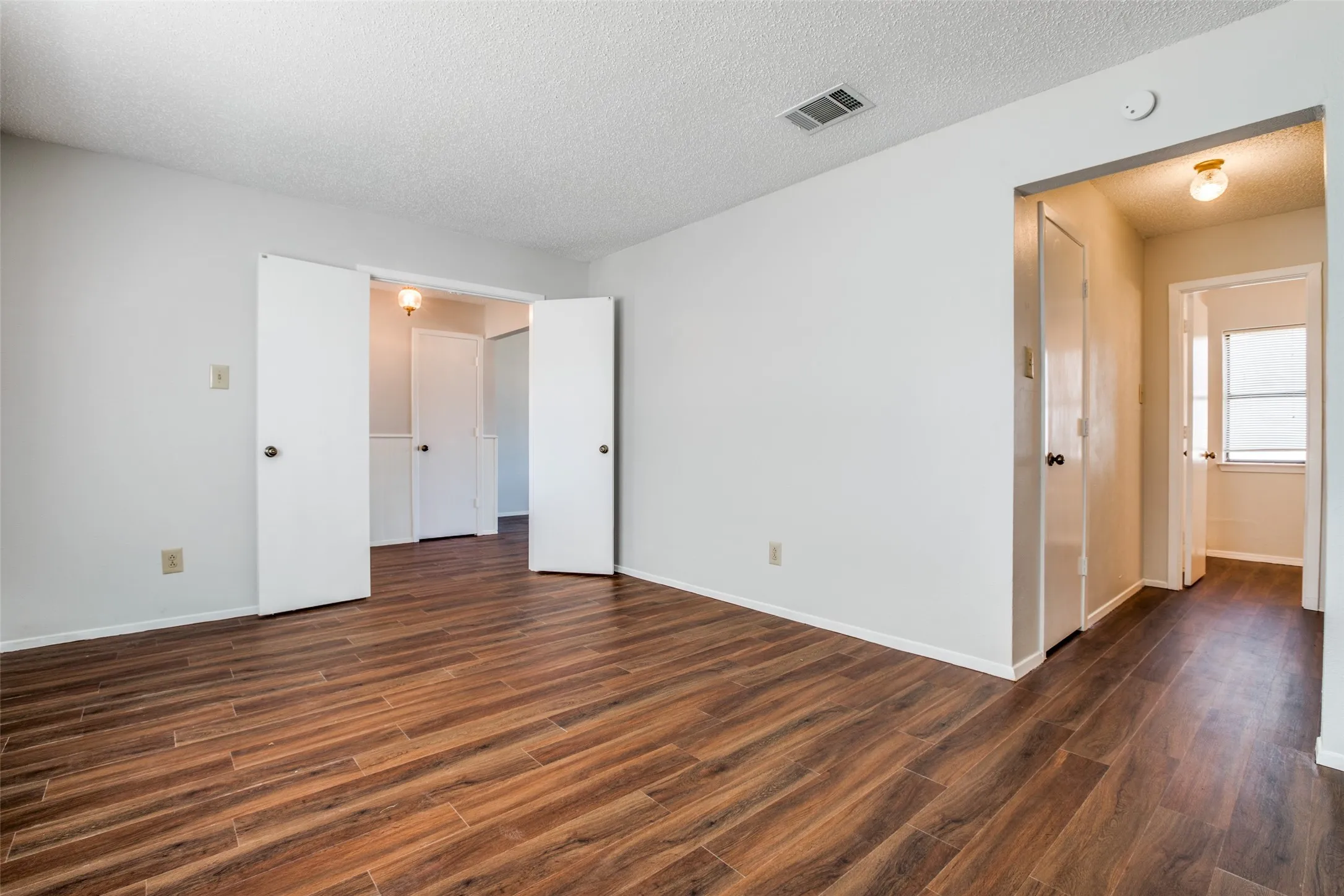 Wood-finish flooring throughout, white walls, and white trim