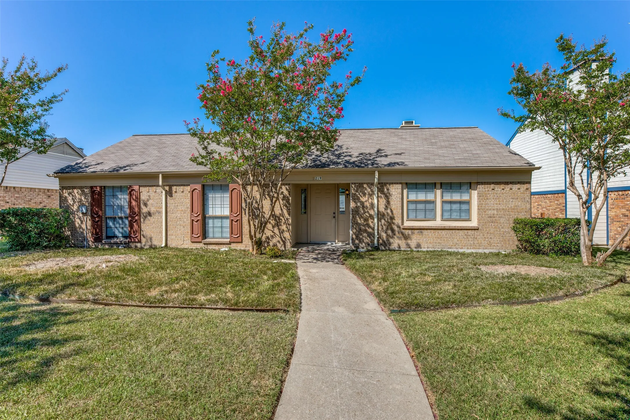 Brick exterior with a gabled roof and decorative window shutters