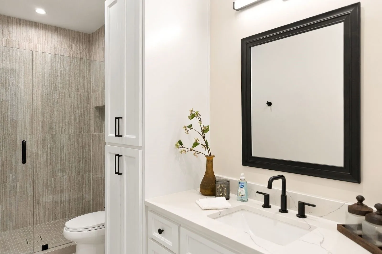 White shaker-style cabinetry with matte black hardware, stone-finish countertop, and undermount sink