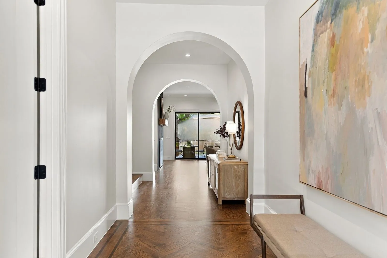 Arched doorways, recessed lighting, and wood-finish flooring with a patterned inlay