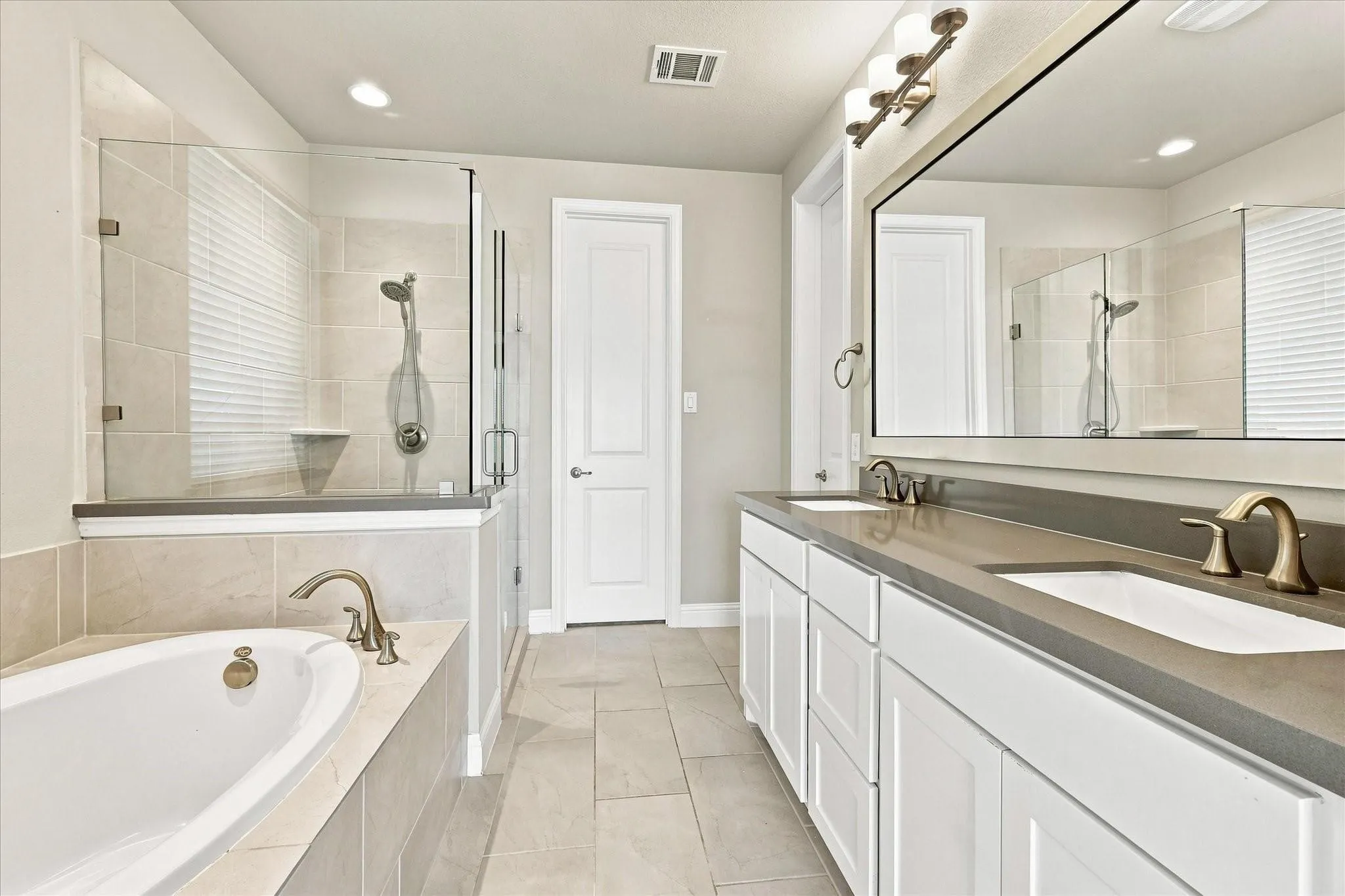 Dual vanity, shower and bathtub in this generously sized primary bathroom