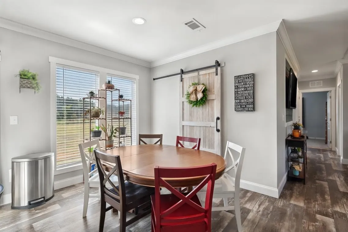 Wood-finish flooring throughout, with a rustic barn door and recessed lighting