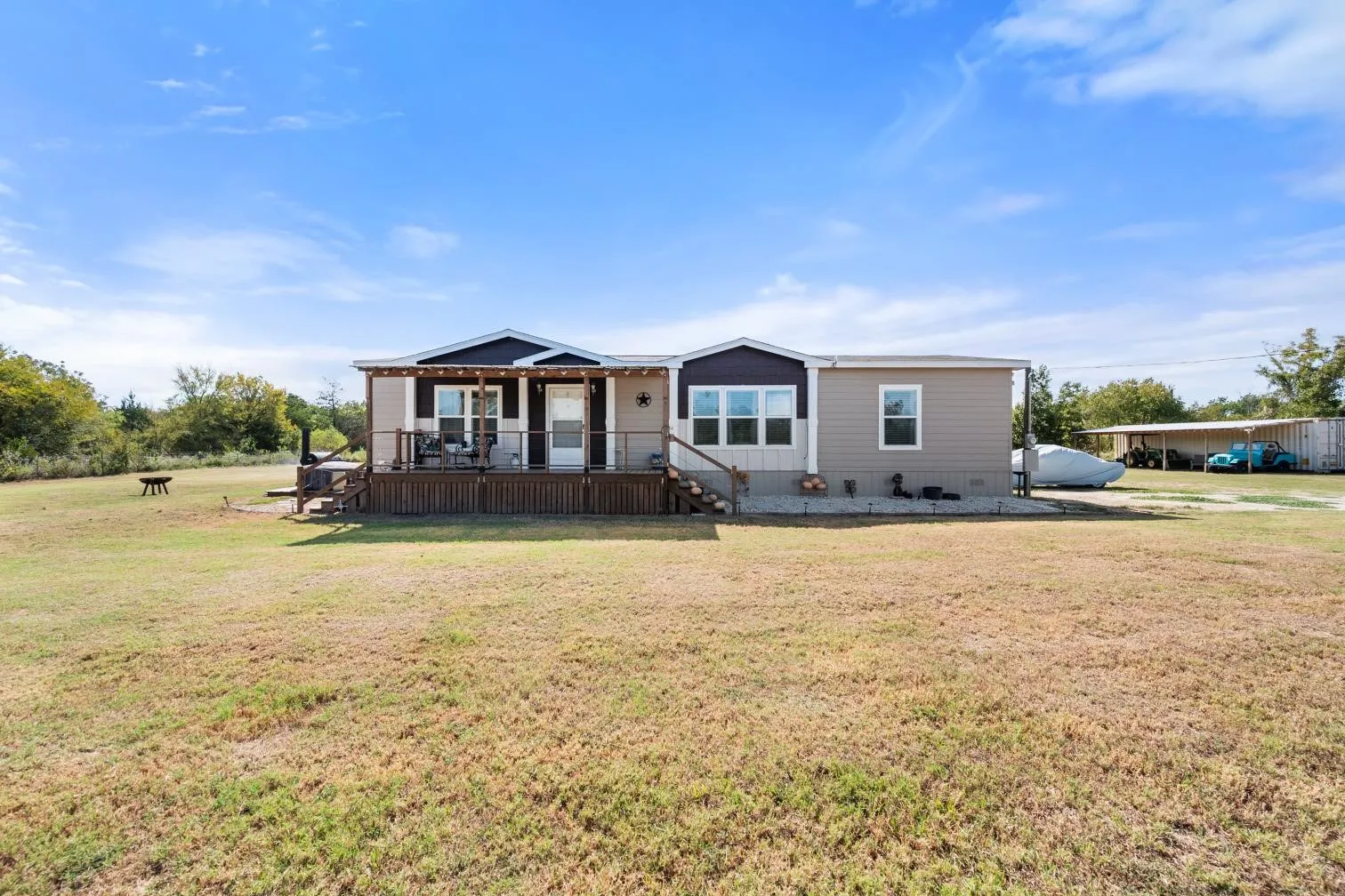 Expansive lot featuring a wide lawn, a covered front porch, and a dedicated storage structure