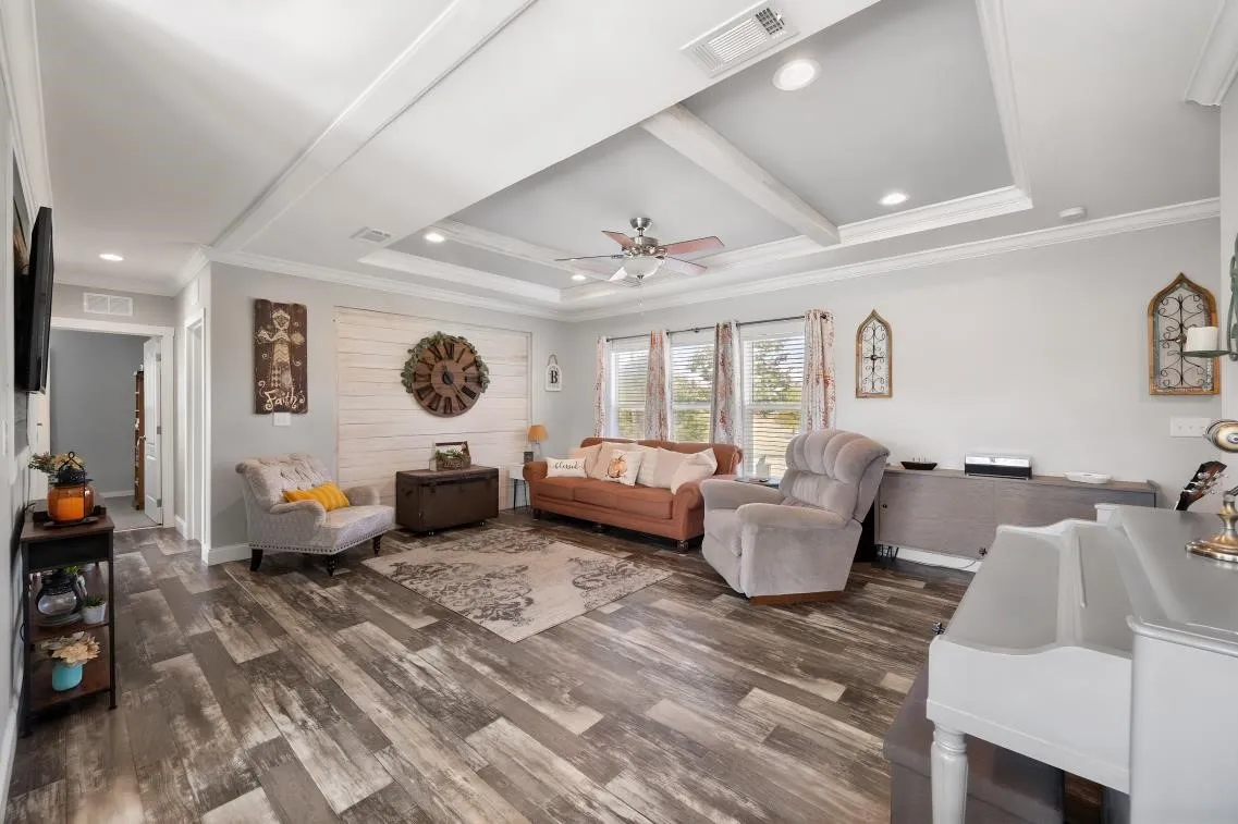 Tray ceiling with recessed lighting, wood-finish flooring, multiple windows, and a shiplap accent wall