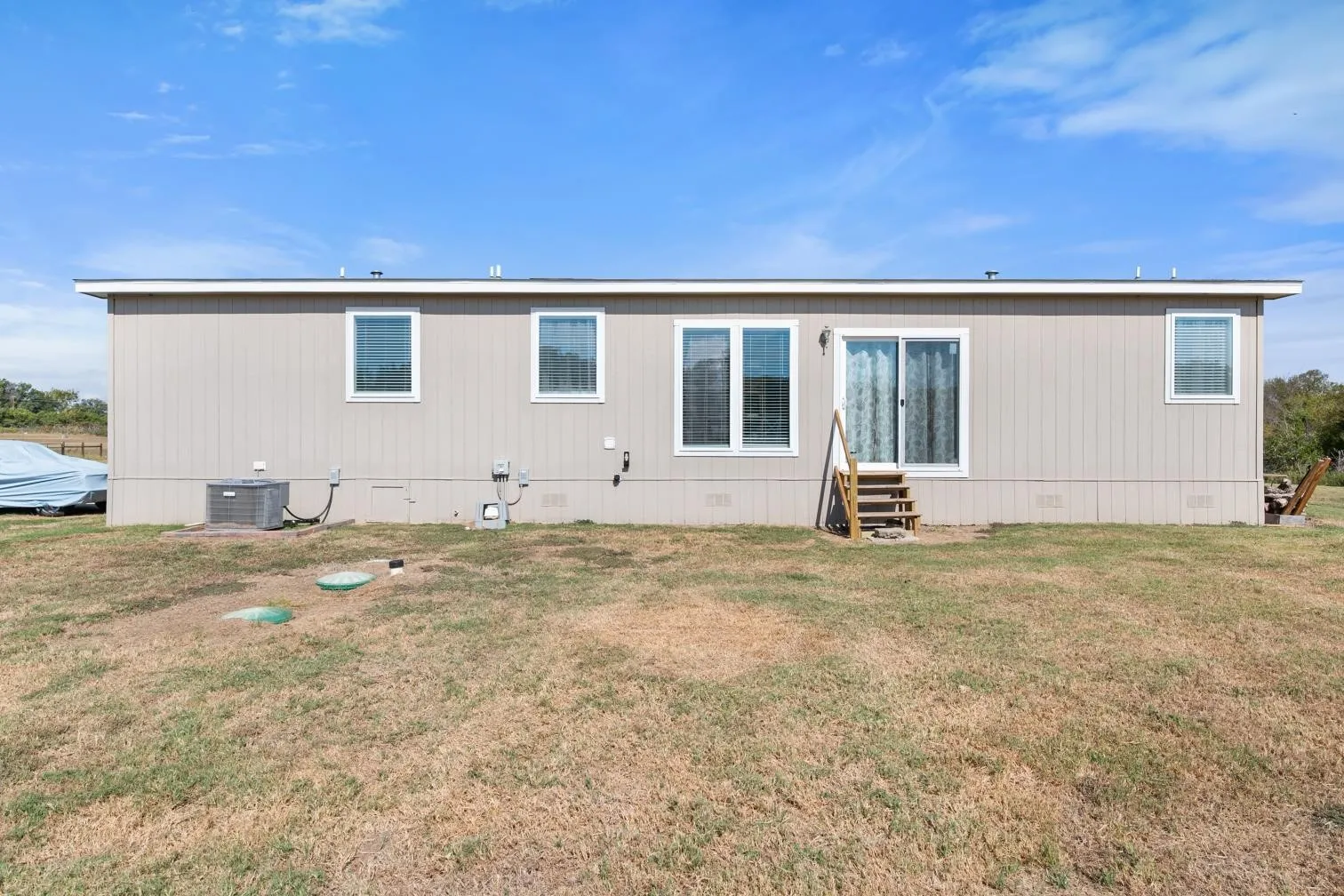 Rear exterior with multiple windows and a sliding glass door
