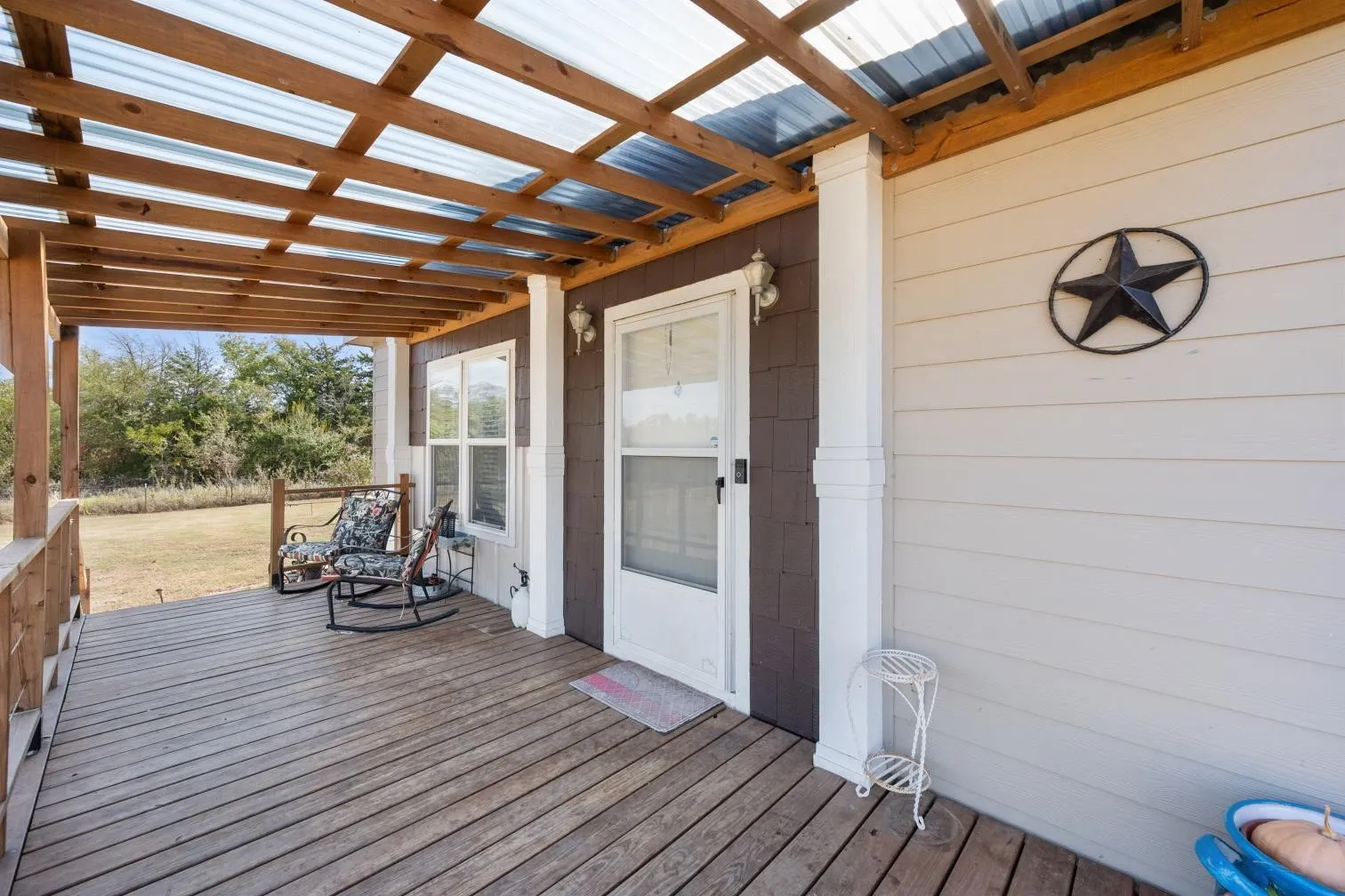Covered porch featuring wood decking and a translucent roof