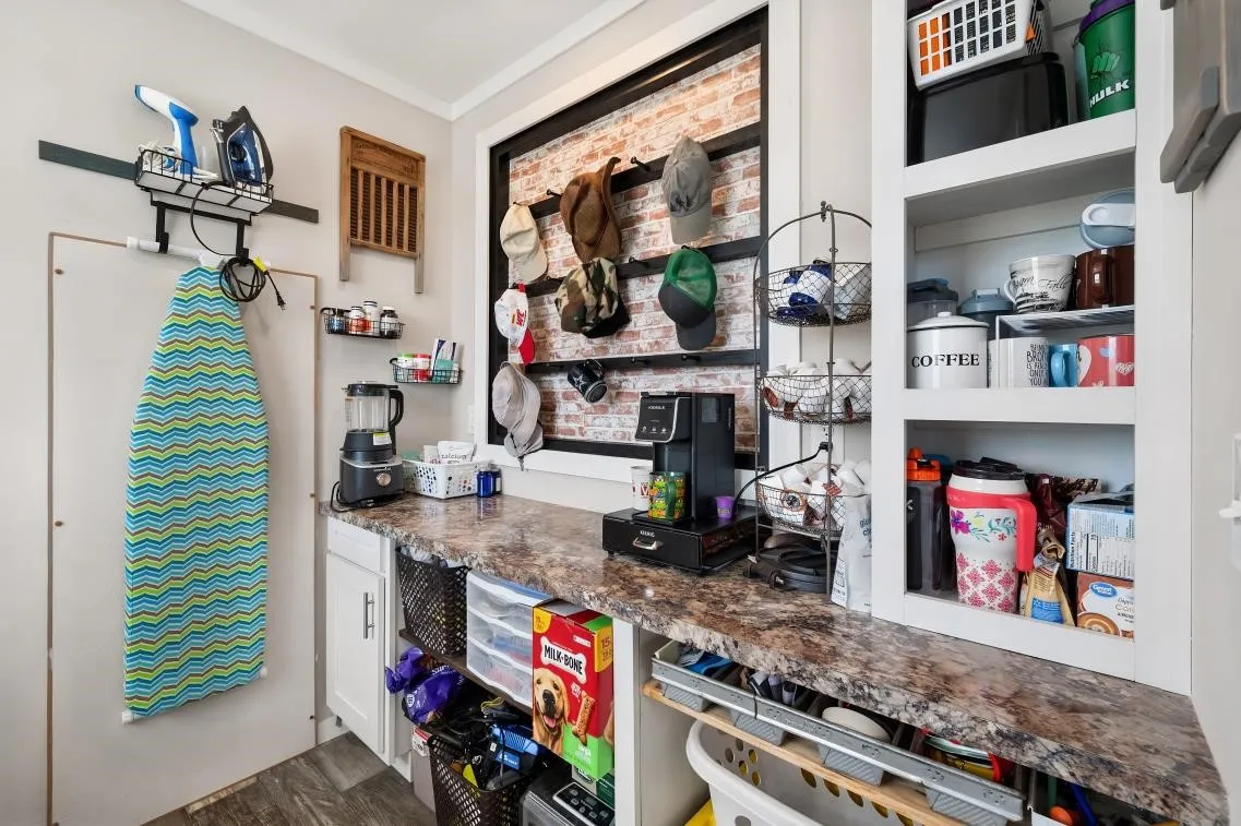 Built-in cabinetry, granite-look countertop, wood-finish flooring, and a brick-finish accent wall