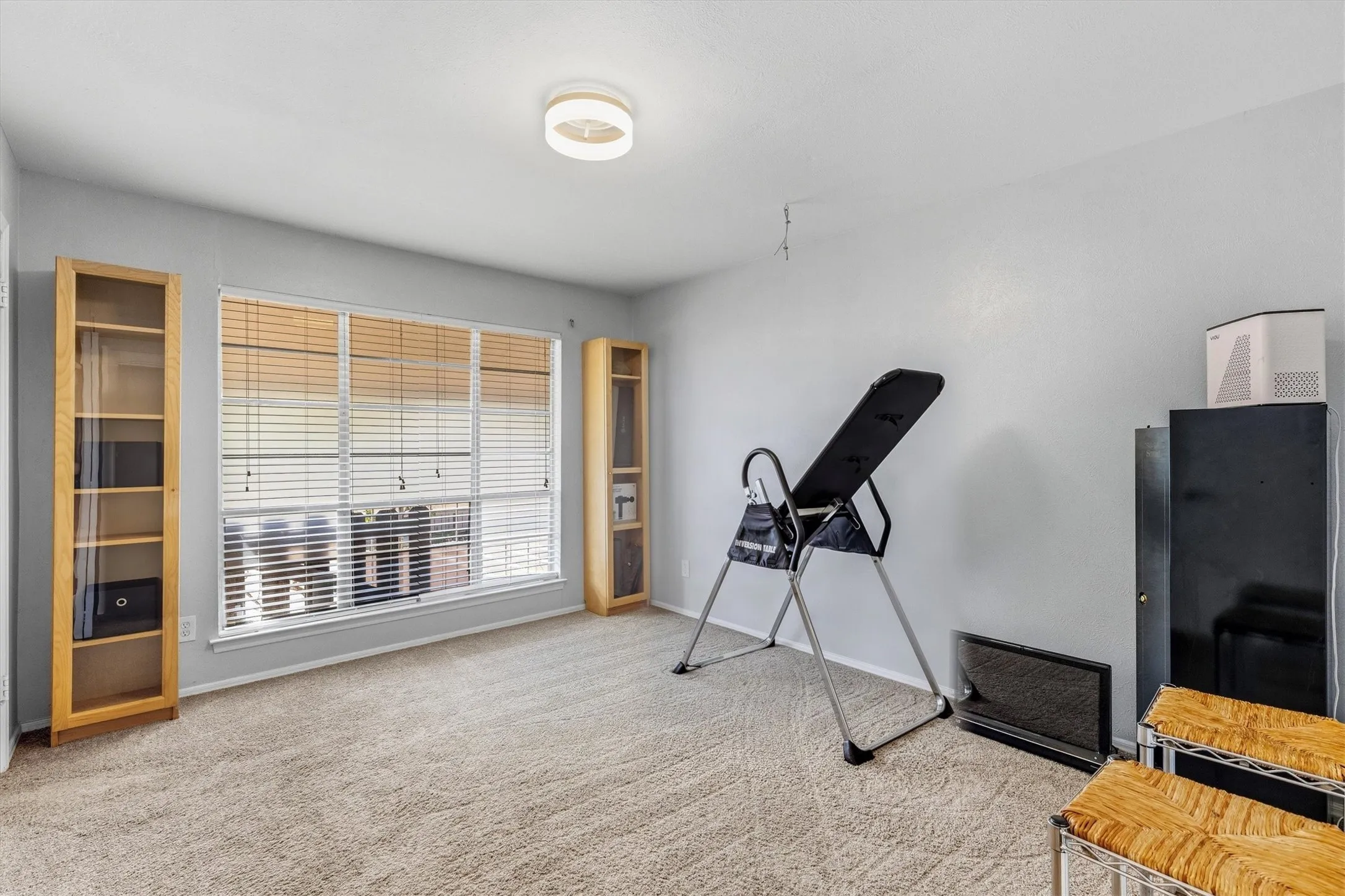Wall-to-wall carpeting with an overhead flush mount light fixture