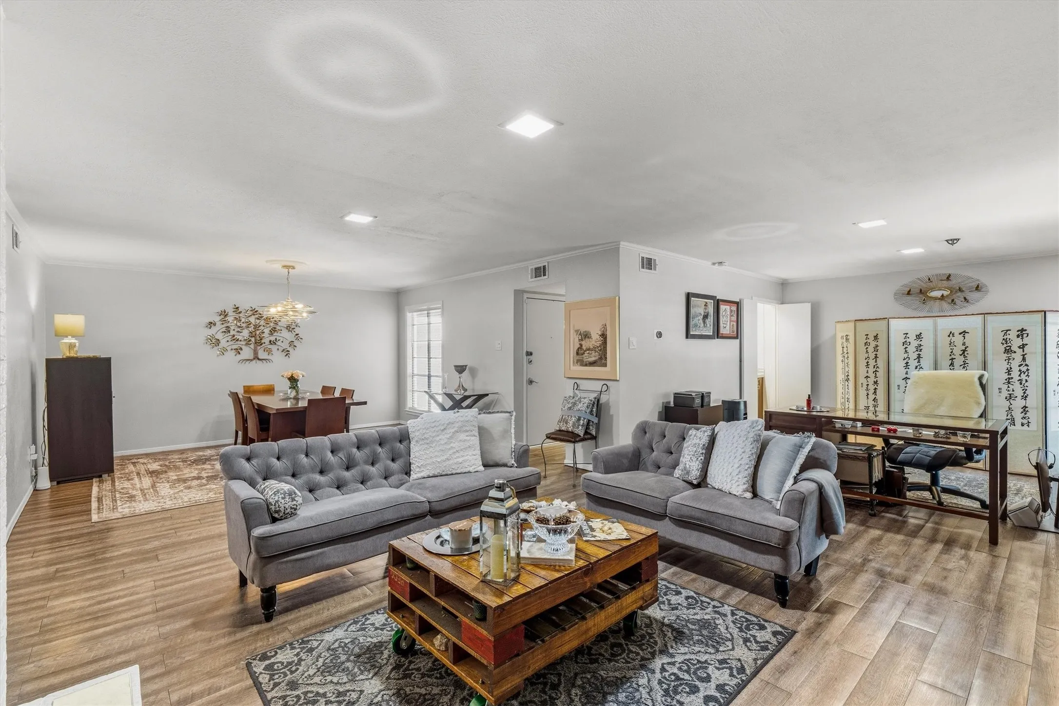 Wood-finish flooring throughout, recessed ceiling lighting, and a chandelier in the dining area