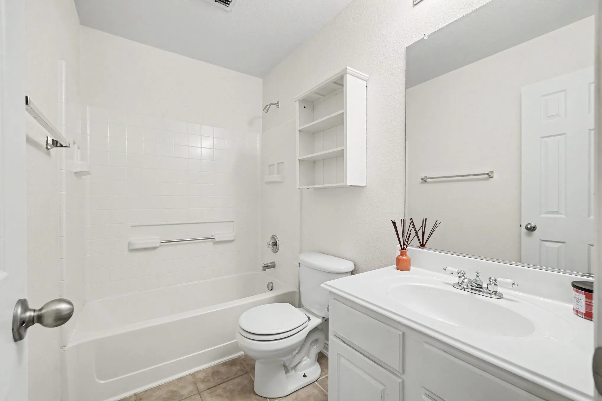 White vanity with integrated sink, chrome-finish faucet, and full-width mirror