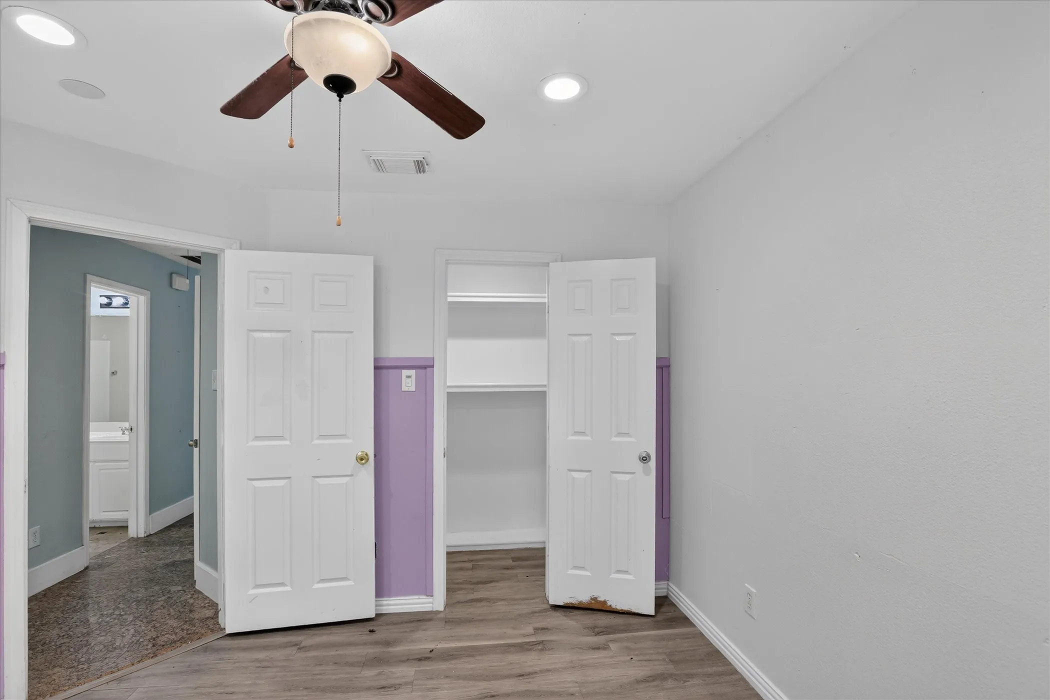 Wood-finish flooring, ceiling fan with light fixture, recessed ceiling lighting, built-in shelving