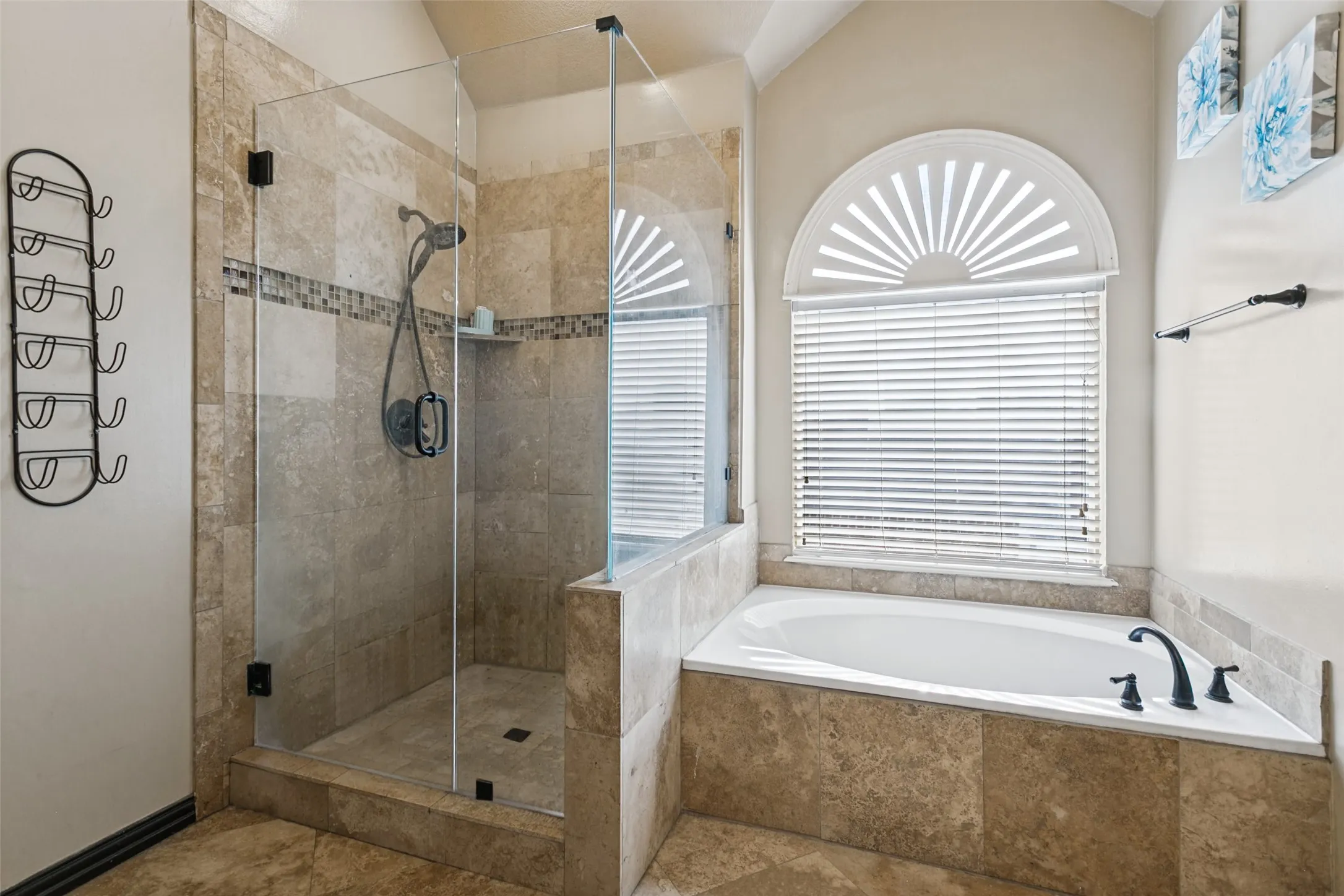 Walk-in shower with clear glass enclosure and tile surround